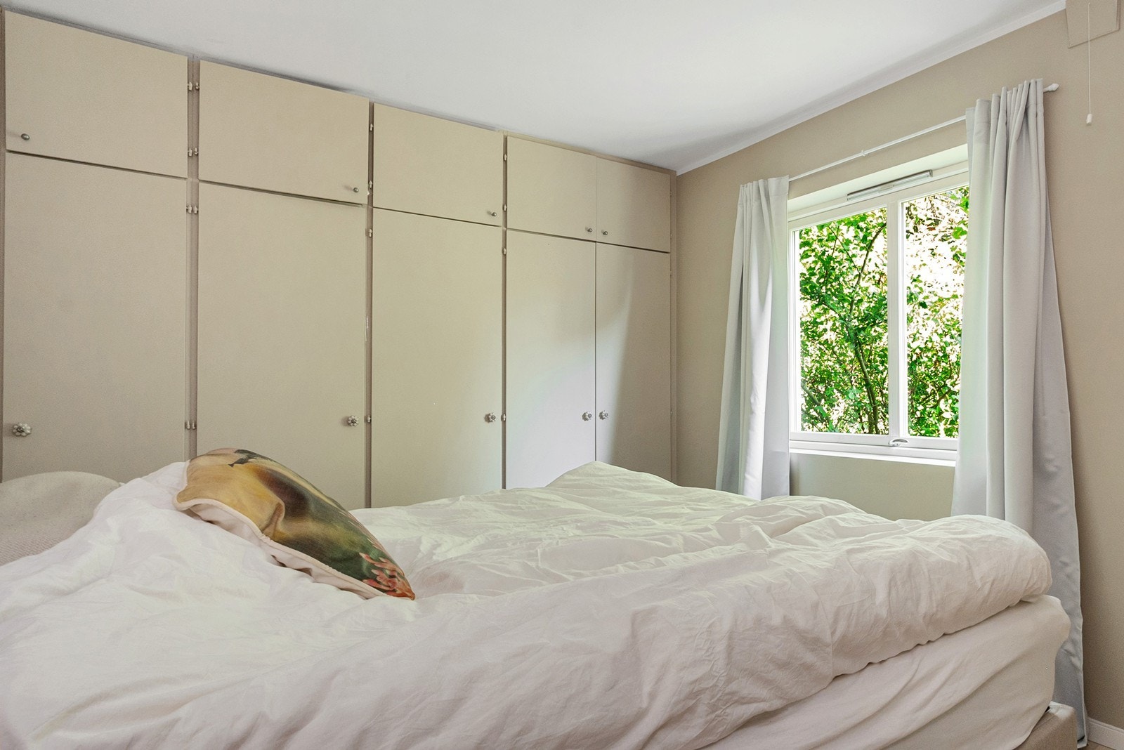 Stort vindu gir naturlig lys og luftemulighet. Leiligheten ligger skjermet uten dirkete innsyn og vender mot den grønne hagen. Galleribilde