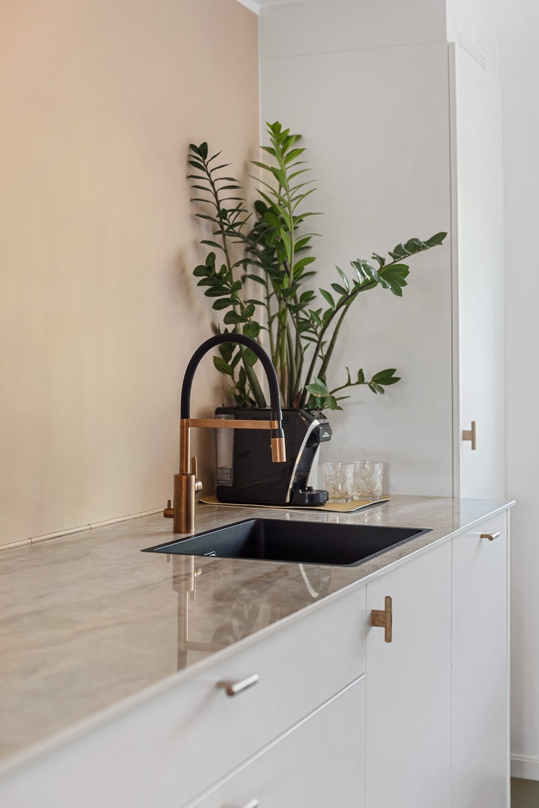 Moderne og lyse fargekombinasjoner er gjennomgående i hele boligen. Sort vask og messingarmatur gir et elegant uttrykk. Galleribilde