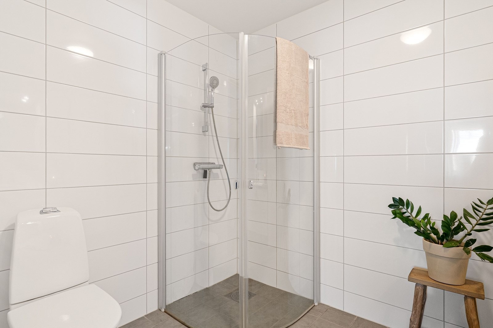 Videre har badet toalett, dusjhjørne med innfellbare dører og mekanisk avtrekk. Galleribilde