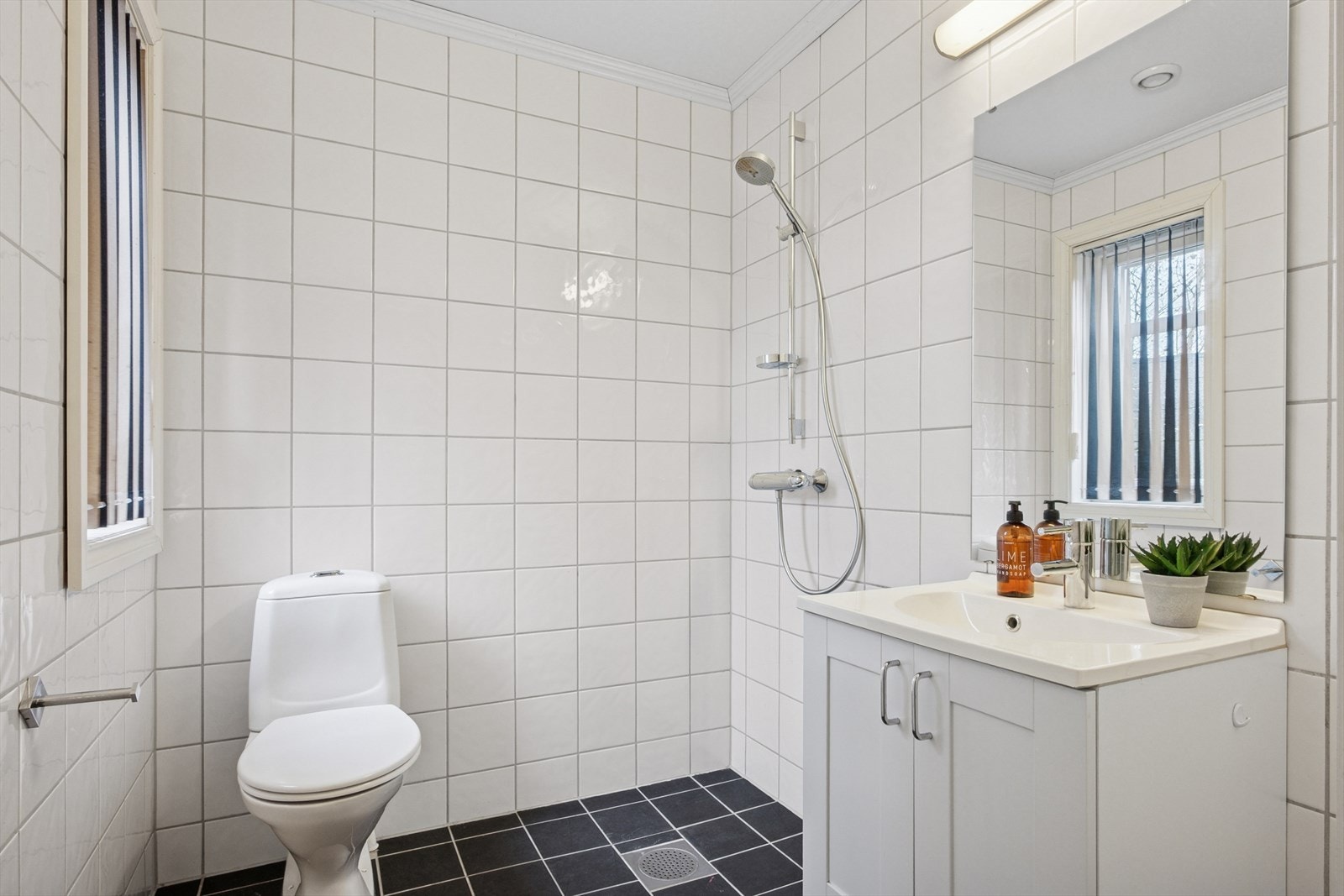 Badet i første etasje er innredet med heldekkende servant, underskap med dører, frittstående toalett og dusjhjørne. Galleribilde