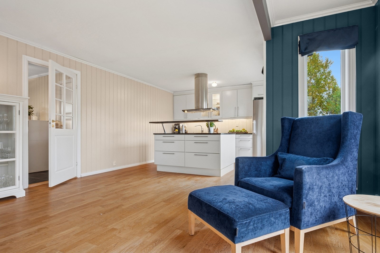 Kjøkkenet ligger i åpen og sosial løsning mot stuen, noe som skaper en naturlig flyt mellom matlaging og måltider Galleribilde