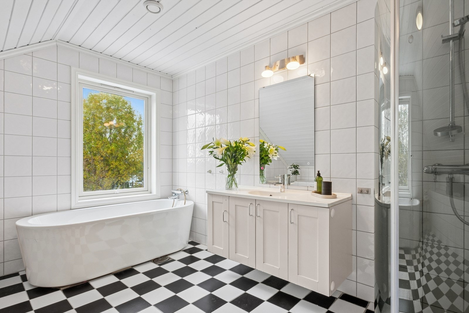 Badet i andre etasje har heldekkende servant, underskap med dører, frittstående toalett, badekar og dusjhjørne med innfellbare dører i herdet glass. Begge badene har mekanisk avtrekk. Galleribilde