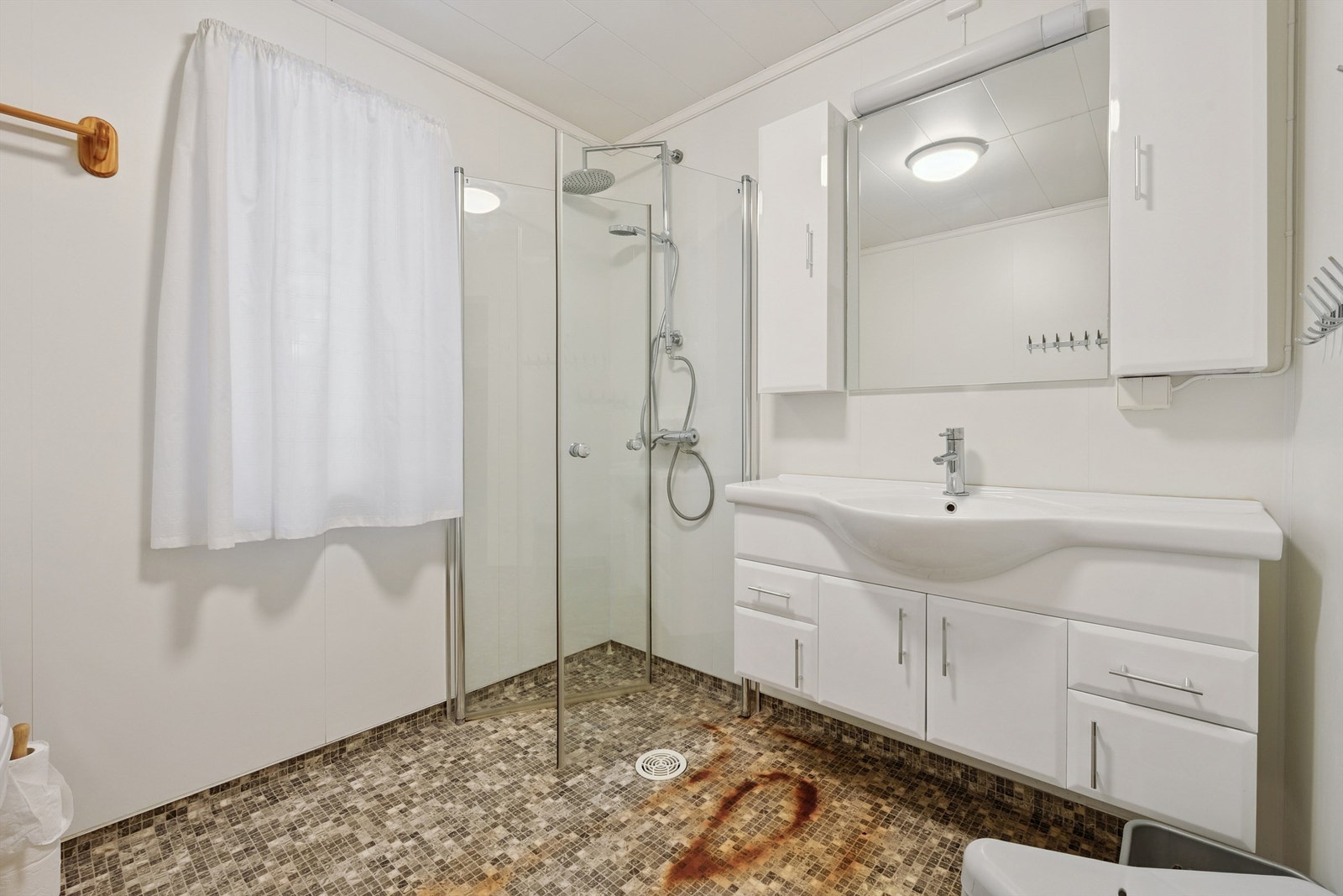 Badet i første etasje er utstyrt med dusjhjørne og servant med underskap. Galleribilde