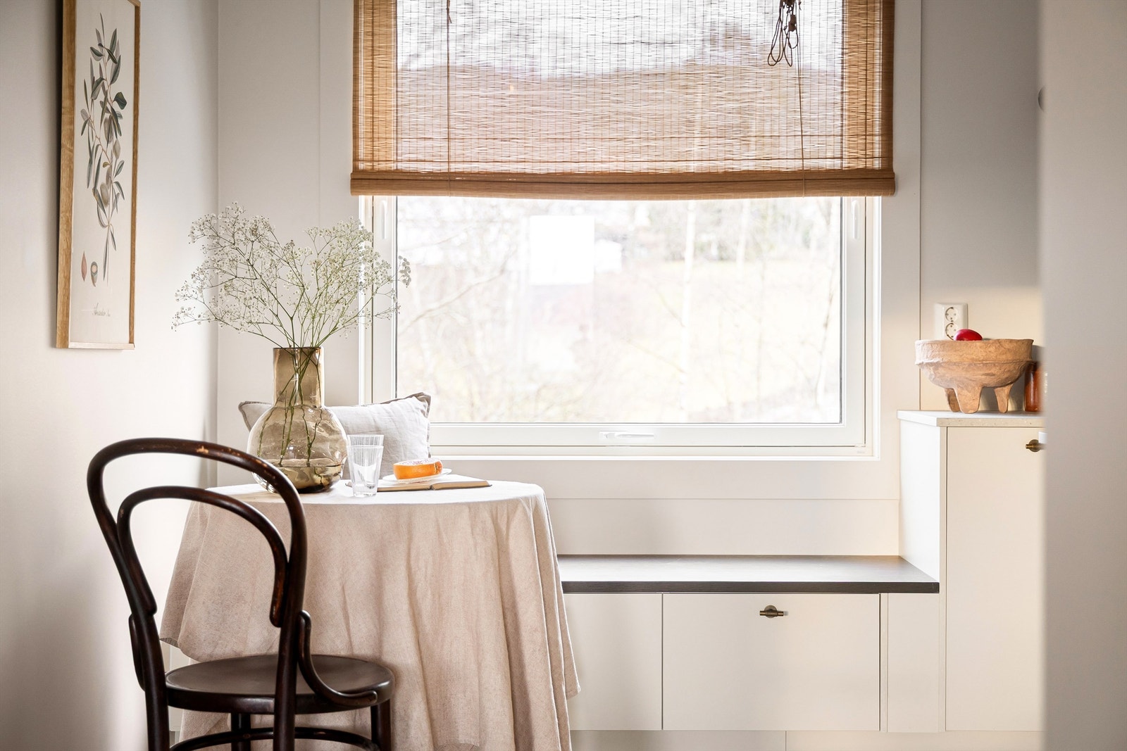 Sittebenken skaper en koselig spiseplass ved kjøkkenvindu med idyllisk utsikt, samt ekstra lagring. Galleribilde