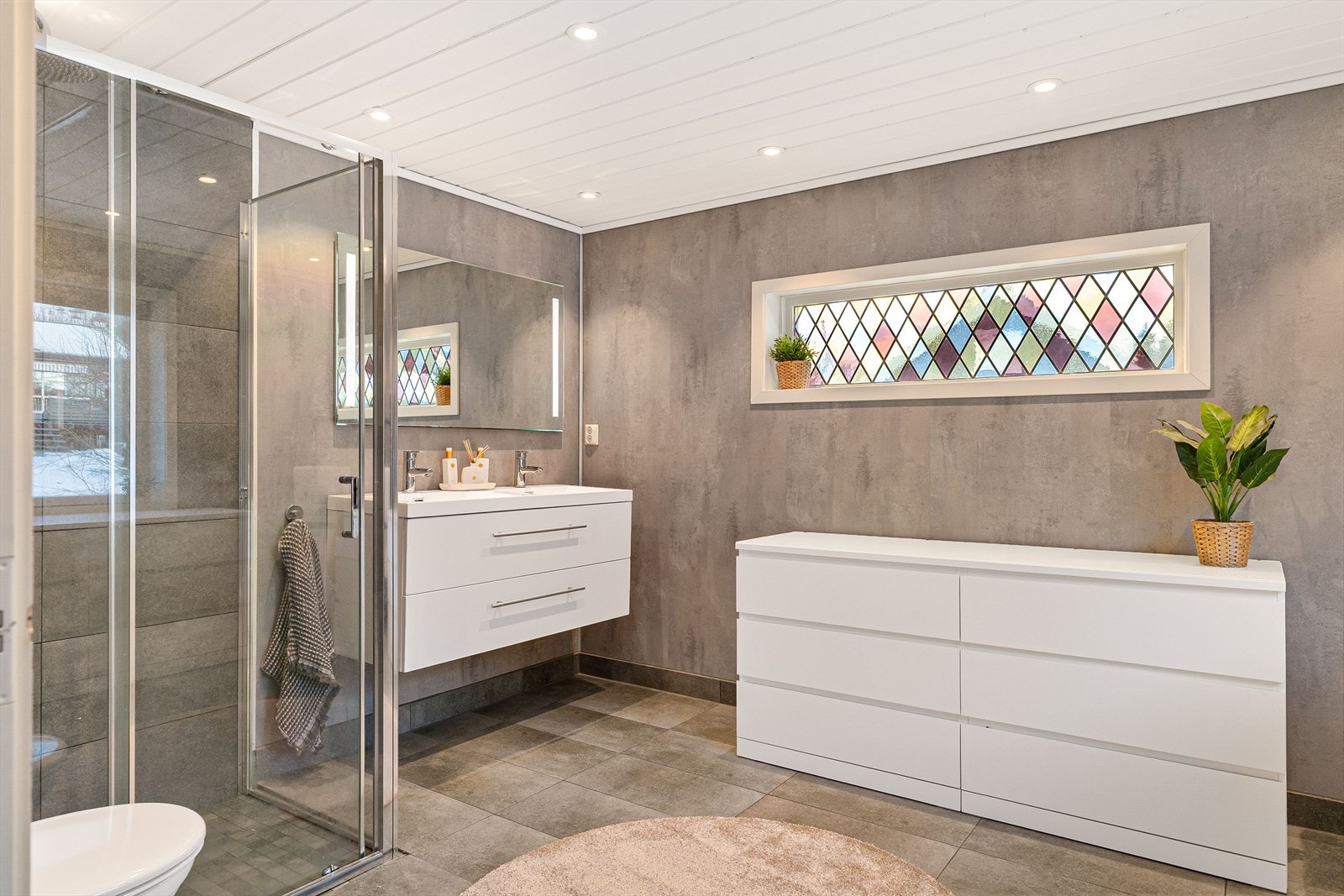 Badet, som er pusset opp i 2017, har et areal på ca. 10 kvm og fremstår moderne og innbydende. Galleribilde