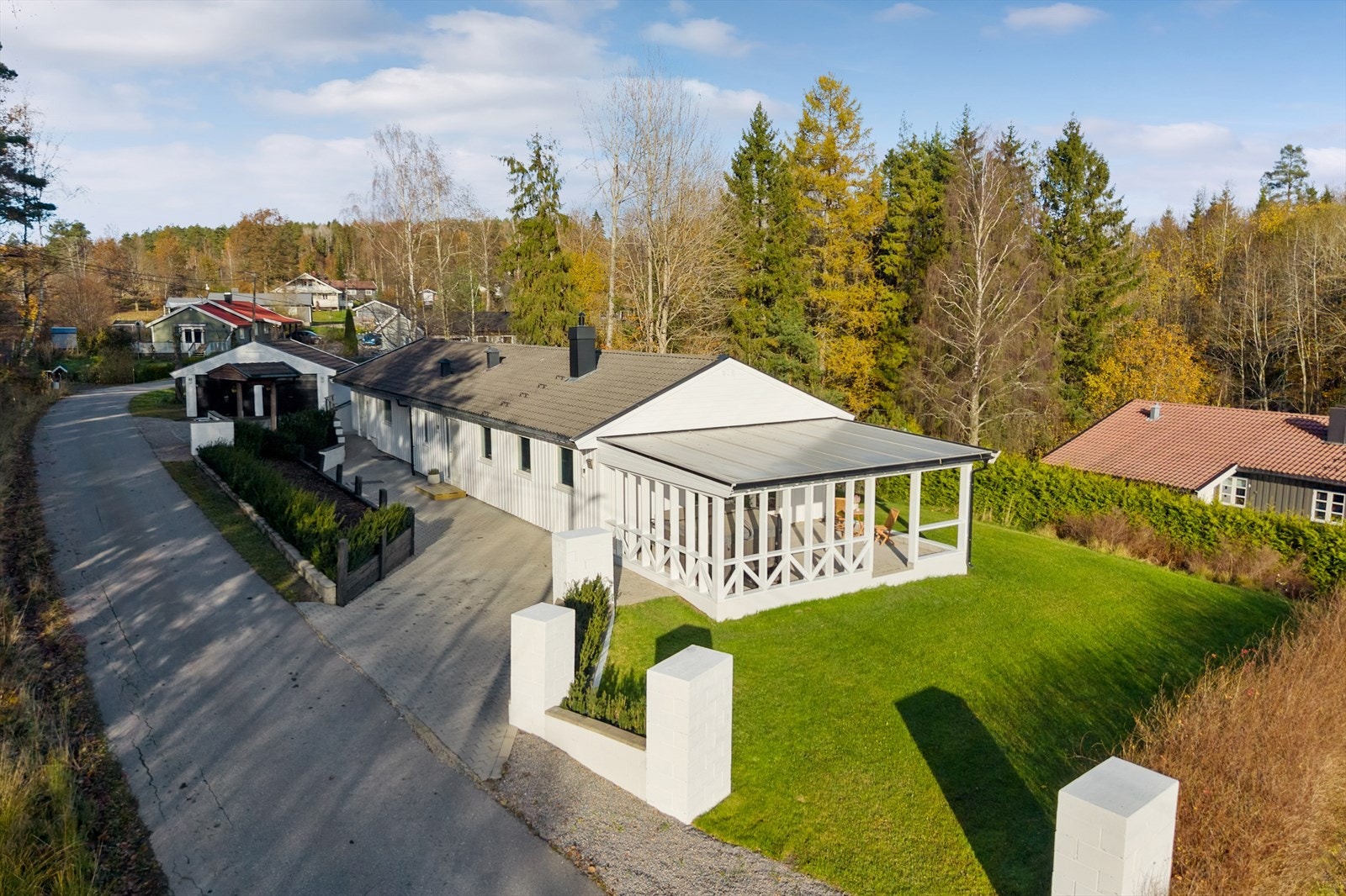 Eiendommen har en overbygd terrasse med plasttak og bærende stolper i tre. Galleribilde