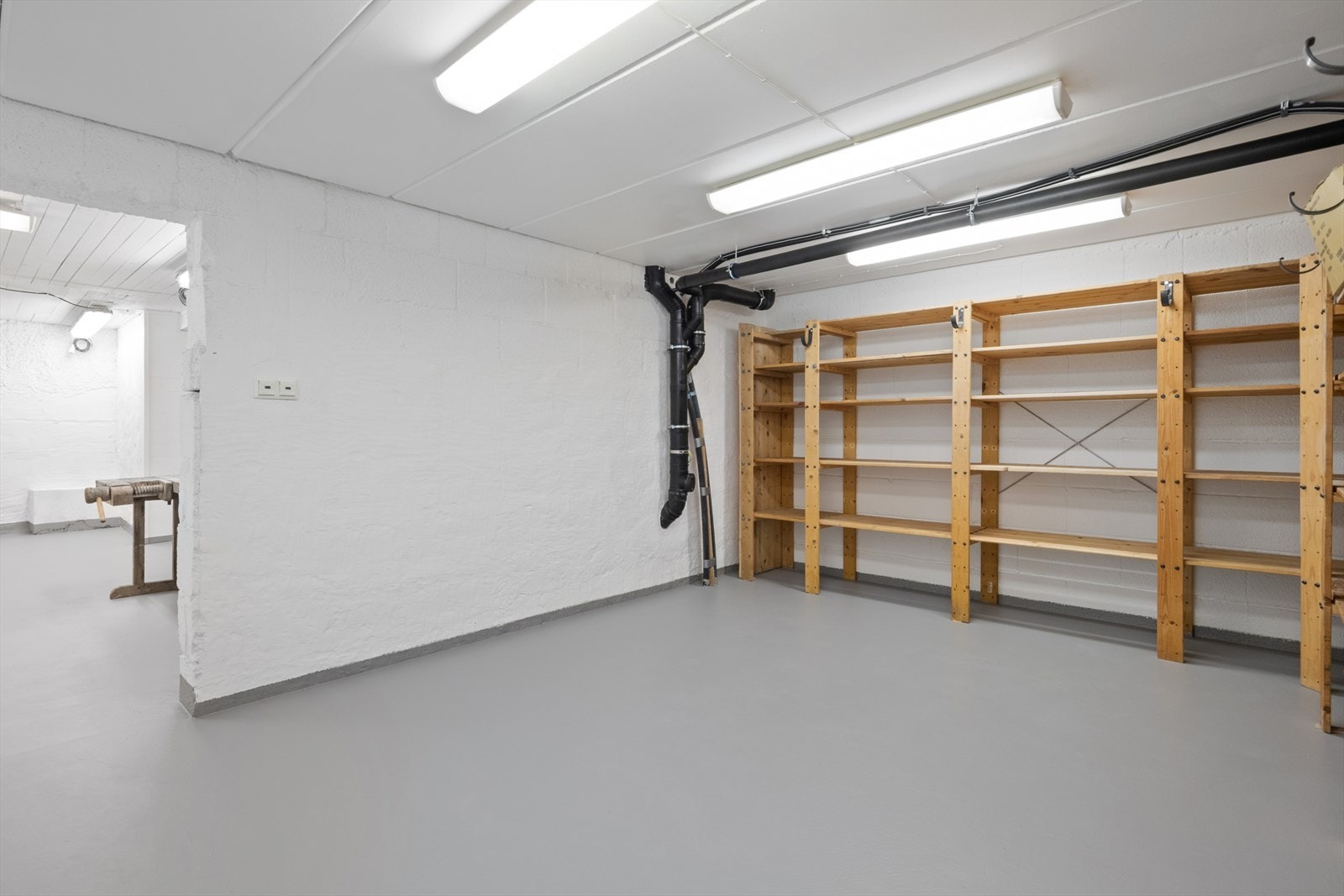 Hylder gir god oppbevaringsplass i et rom med malt murvegg. Galleribilde