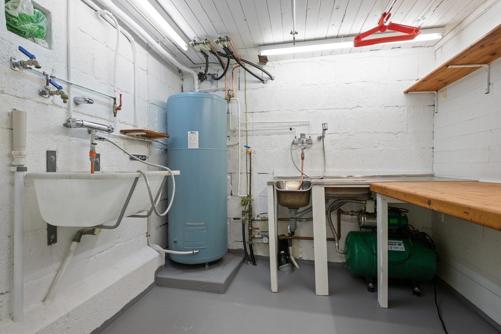 Teknisk rom med varmtvannstank og vask gir funksjonalitet for vaskeromsbruk. Galleribilde