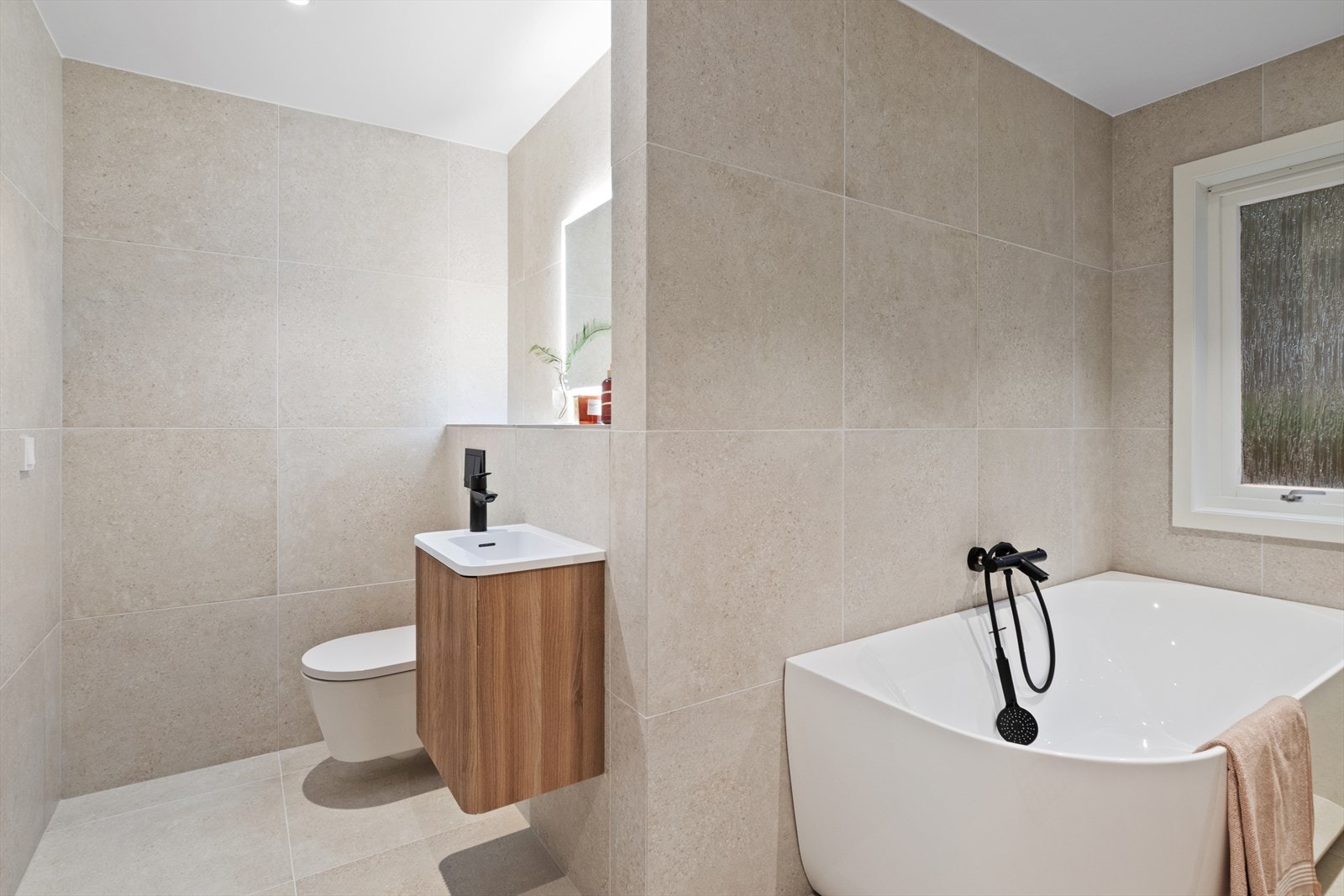 Frittstående badekar og dusjvegger i glass gir en moderne baderomsløsning. Galleribilde