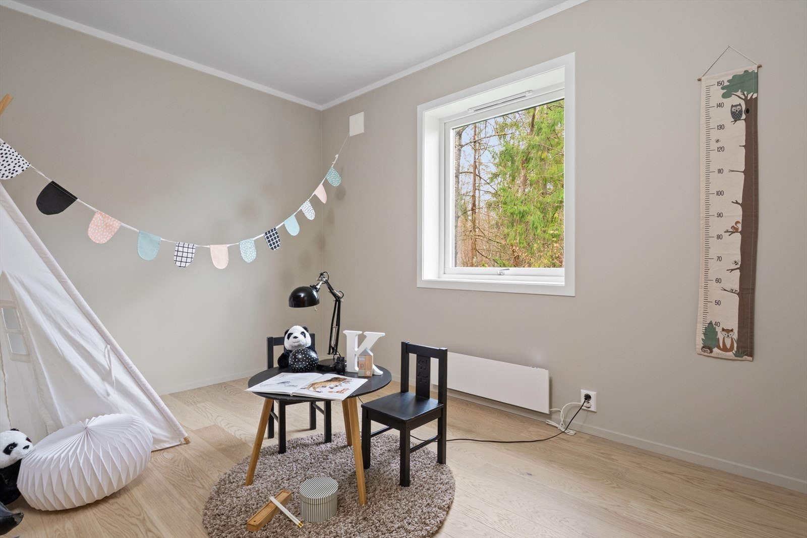 Barnerom med parkettgulv og vindu som gir utsyn til grøntområde. Galleribilde