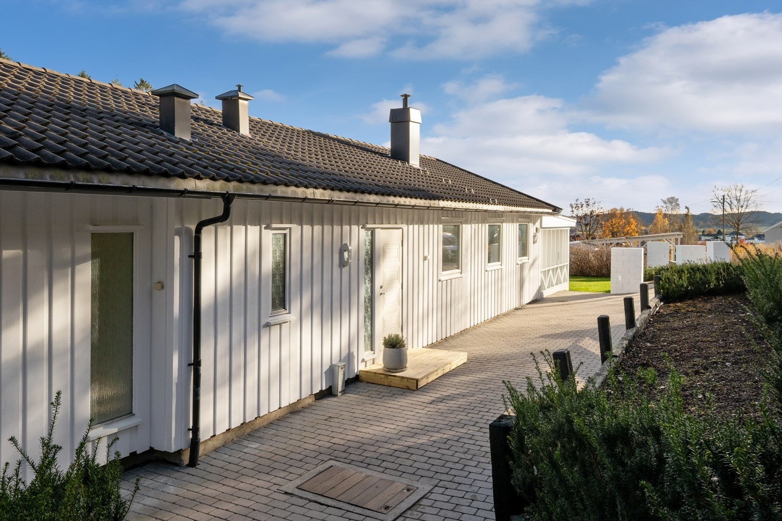 Inngangspartiet er flislagt med belegningsstein, og det er montert en platting ved døren. Galleribilde