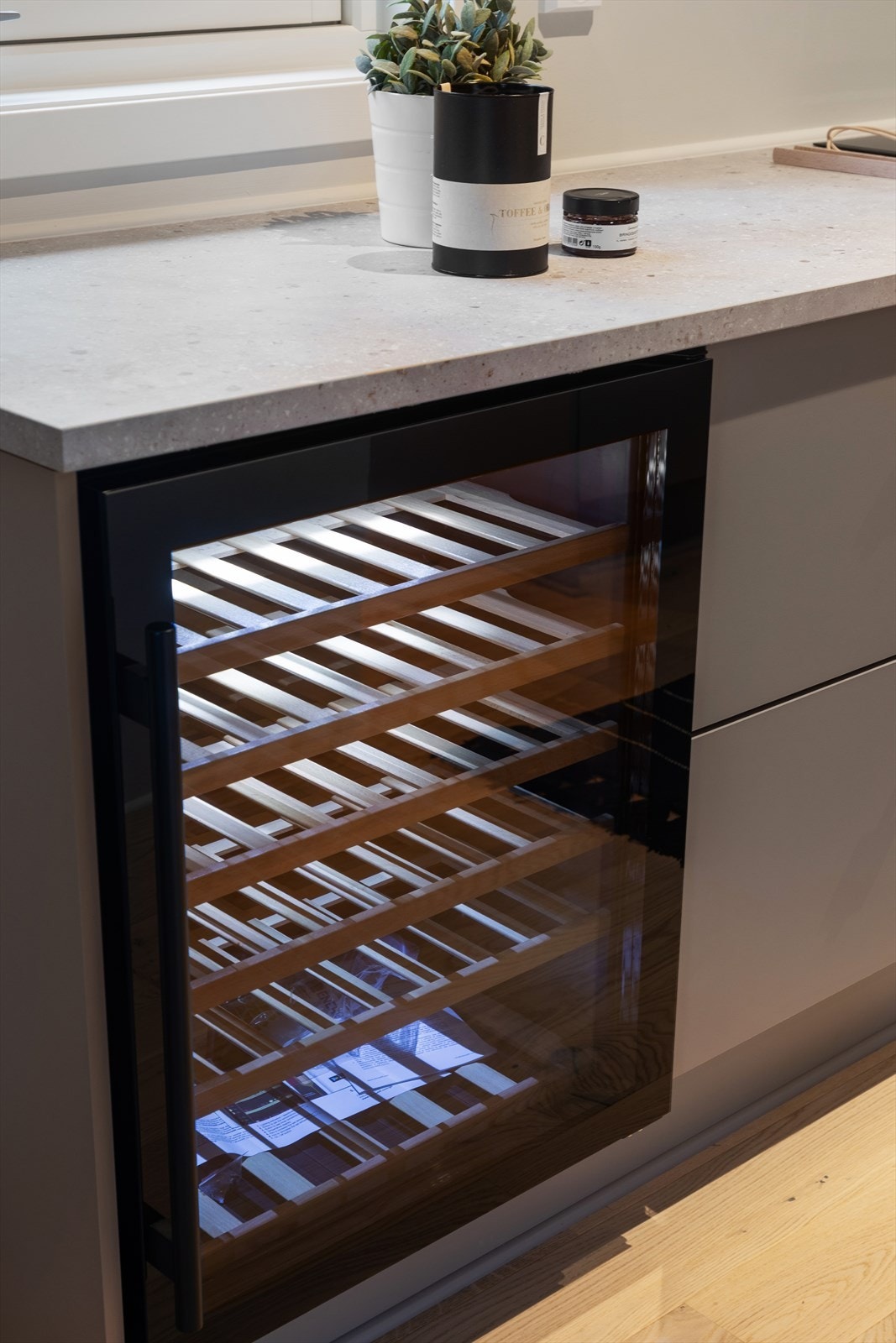 Vinskap integrert i kjøkkeninnredningen for praktisk oppbevaring. Galleribilde