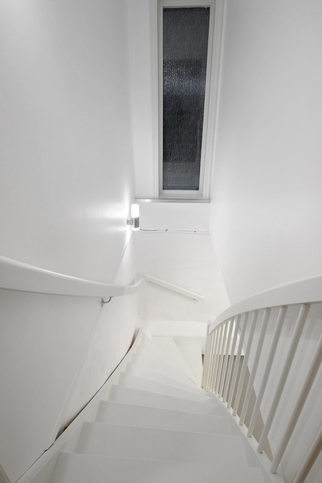 Innvendig trapp i malt treutførelse gir forbindelse mellom etasjene. Galleribilde