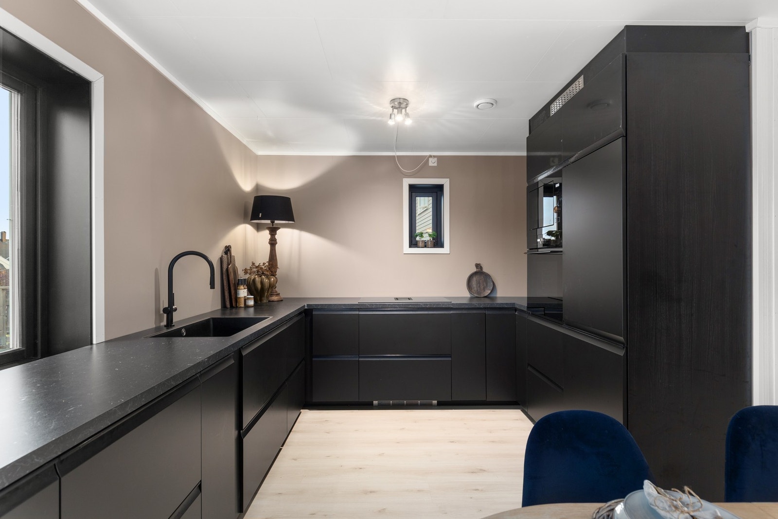 Sstilrent kjøkken med integrert kjøl/fryseskap, stekeovn, mikroovn og oppvaskmaskin og platetopp med avtrekk. Galleribilde