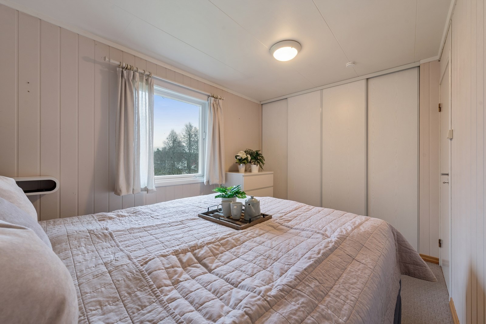 En praktisk skyvedørsgarderobe fra vegg til vegg gir soverommet et ryddig og moderne uttrykk. Galleribilde