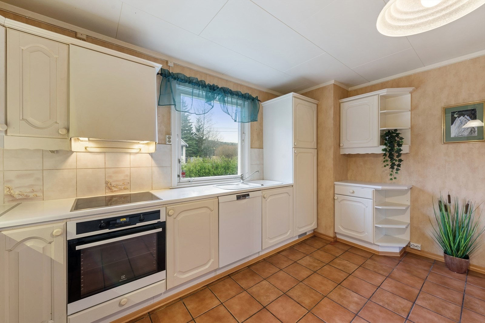 Kjøkkeninnredning fra 1985 med profilerte fabrikklakkerte fronter. Benkeplate i laminat med nedfelt kum. Galleribilde