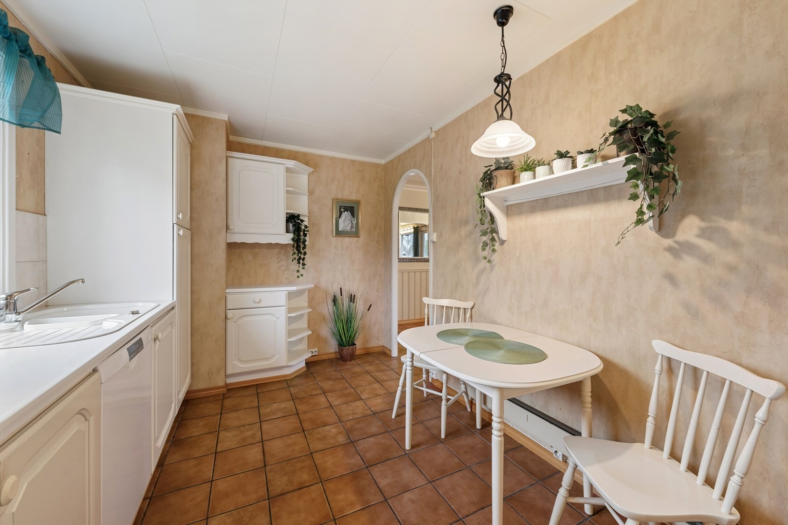 Kjøkkenet har et flislagt gulv og tapetserte vegger. Galleribilde