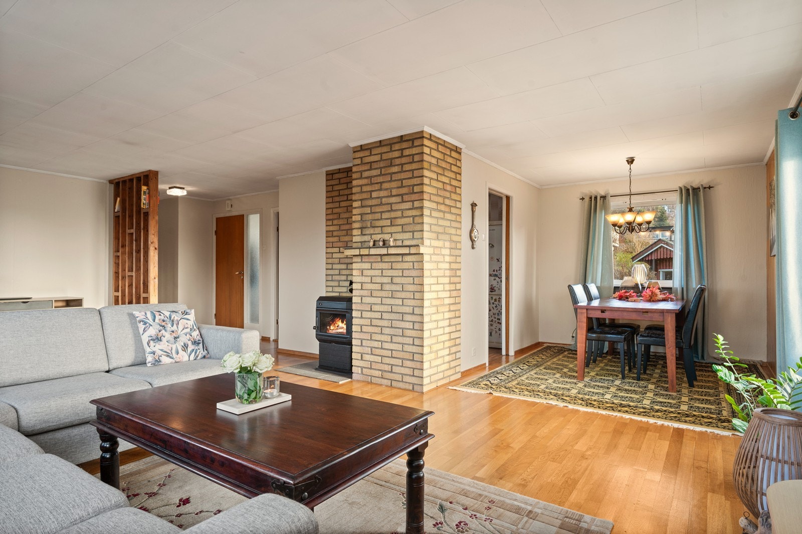 Stuen er romslig med en sentralt plassert vedovn og en egen sone for spisestue. Galleribilde