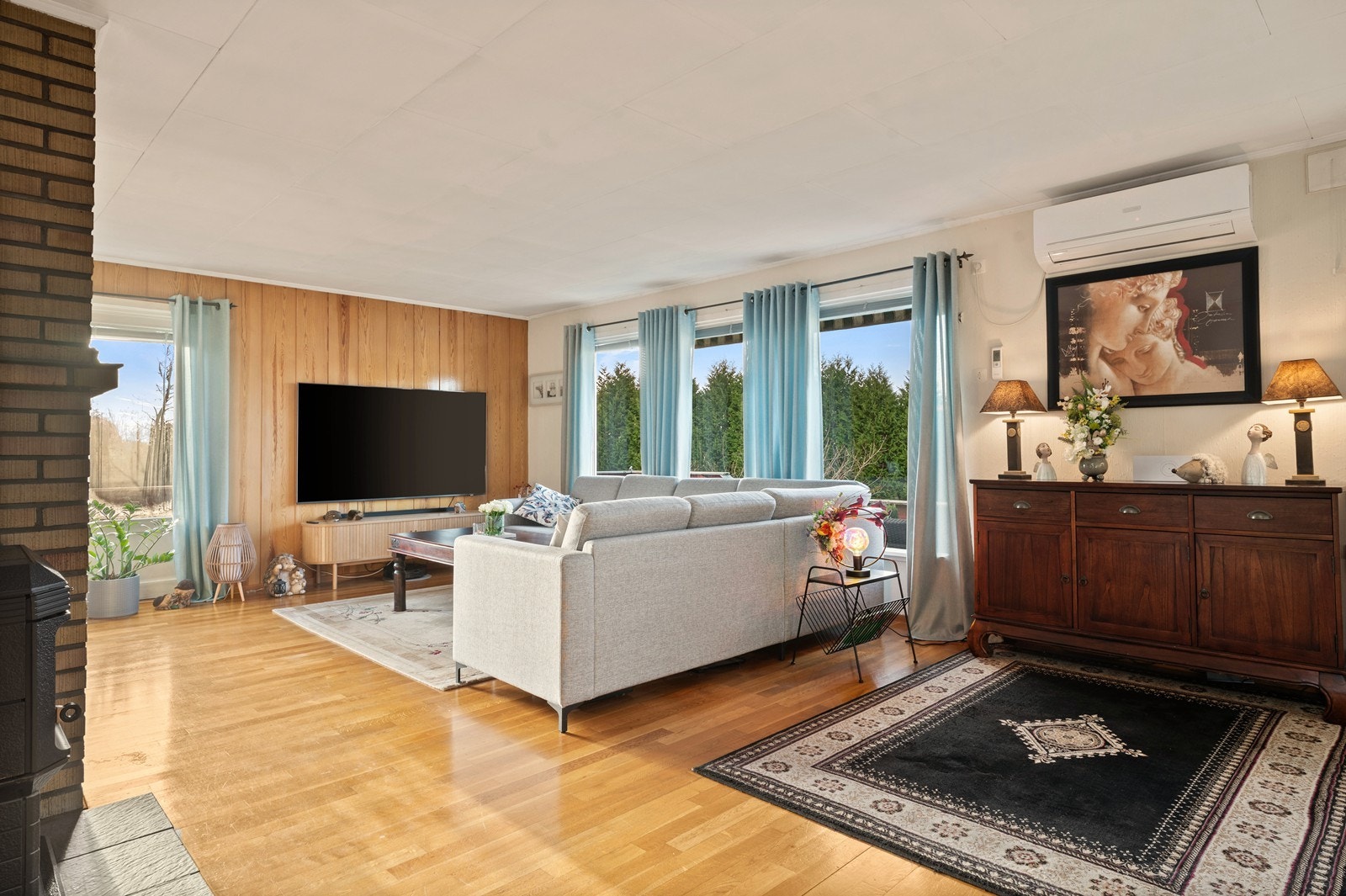 Store vindusflater gir rikelig med naturlig lys og utsikt mot hagen. Her er det også montert en varmepumpe i fra 2012. Galleribilde