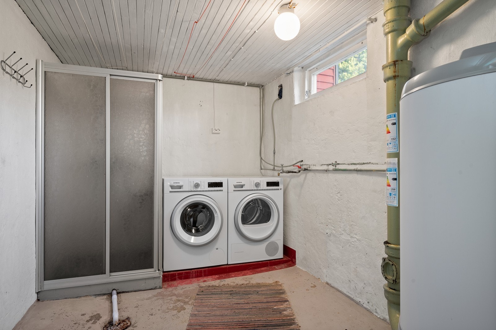 Stort og praktisk vaskerom i kjeller, med kjellerstandard. Her er det opplegg for vaskemaskin, tørketrommel og et eget dusjkabinett. Galleribilde