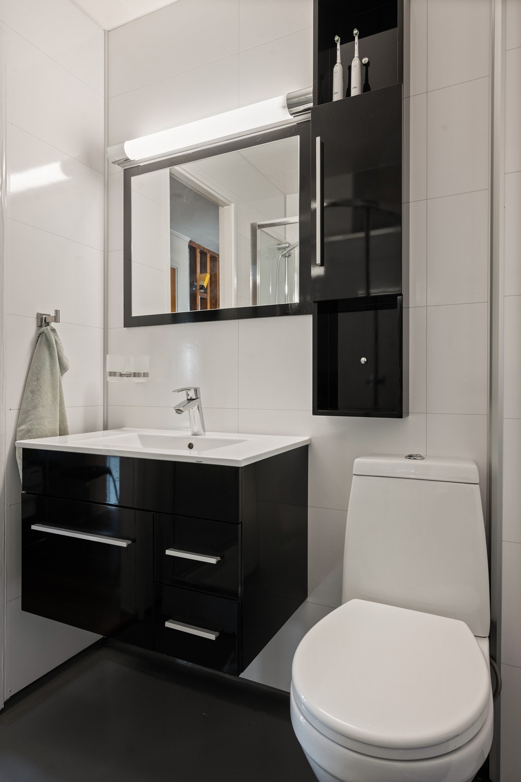 Baderommet ble delvis oppgradert i 2020 med våtromsplater på veggene, etter en fuktskade. På gulvet er det eldre belegg behandlet med epoxy, med behov for utbedring. Rommet er utstyrt med toalett og en moderne servantinnredning. Galleribilde