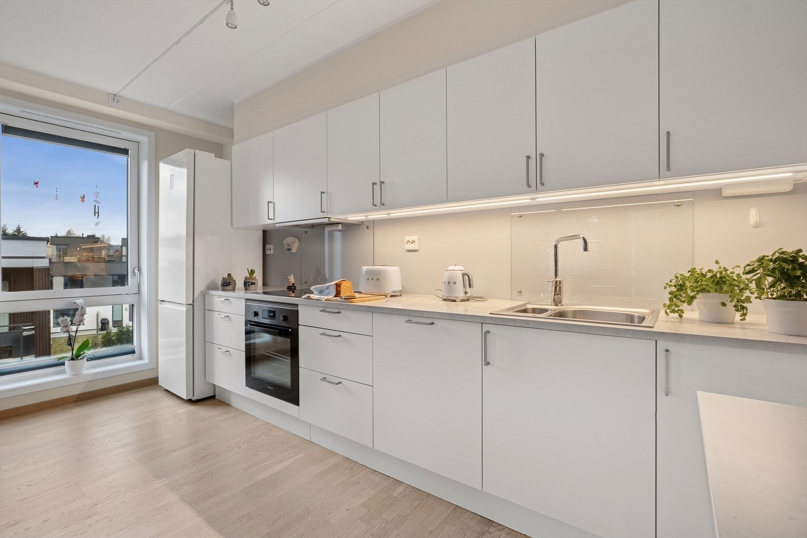 Kjøkkenet har innredning med glatte fronter og benkeplaten av laminat. Galleribilde