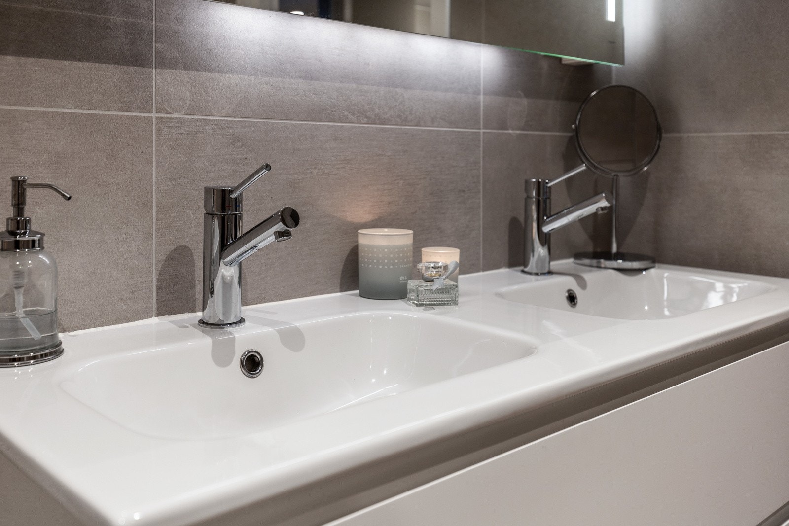 Baderomsinnredningen består av et hvitt skuffemøblement med gripekanter og heldekkende dobbelservant. Galleribilde