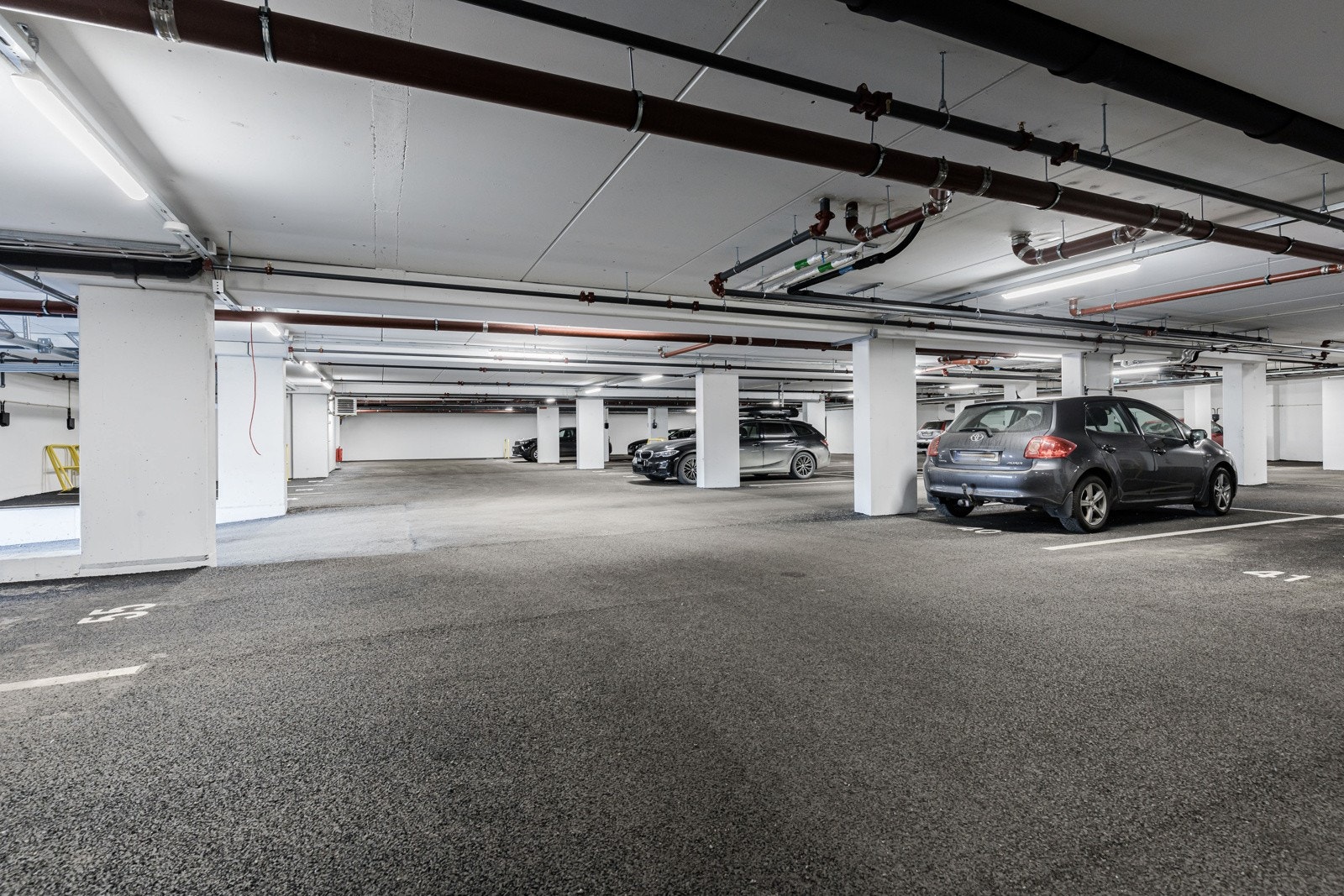 Det medfølger parkeringsplass i felles garasjekjeller hvor det er installert elbillader. Det er noen gjesteparkeringsplasser i samme garasjeanlegg. Galleribilde