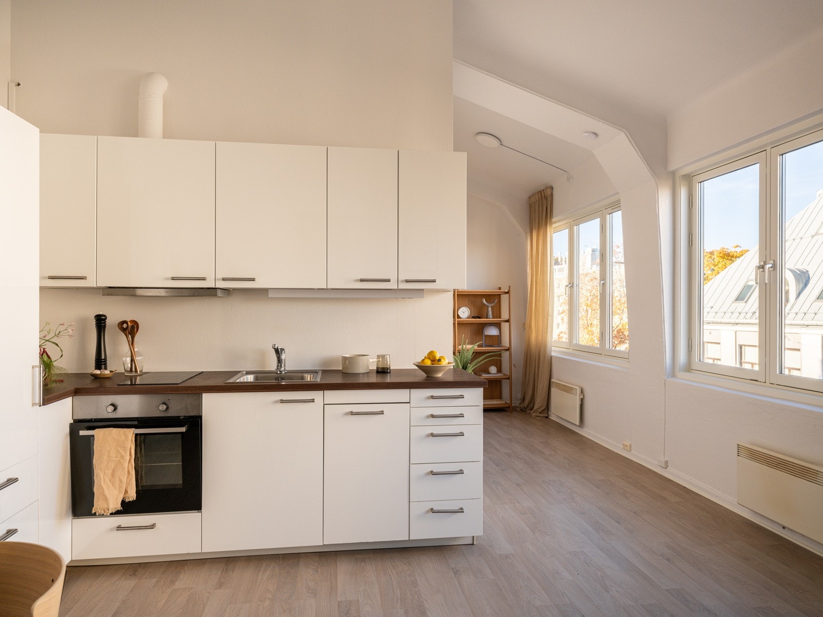 Lyst og moderne Ikea-kjøkken som var nytt i 2015. Innredningen har hvite glatte fronter og laminert benkeplate med nedfelt oppvaskkum. Praktisk med belysning under overskap. Galleribilde