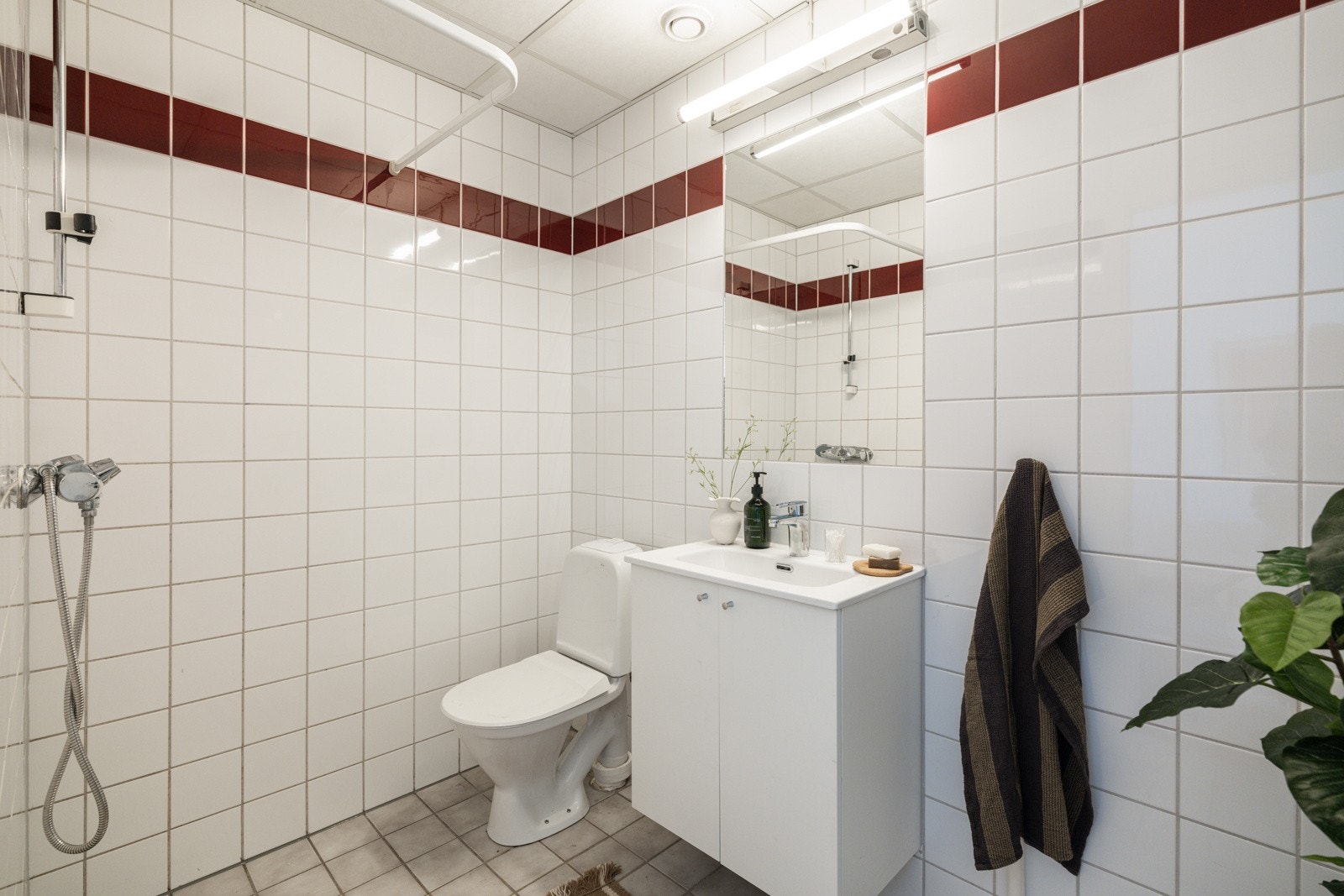 Leiligheten har et flislagt baderom med elektriske varmekabler i gulv og mekanisk avtrekk. I hjørnet er det plass og opplegg for vaskemaskin. Galleribilde
