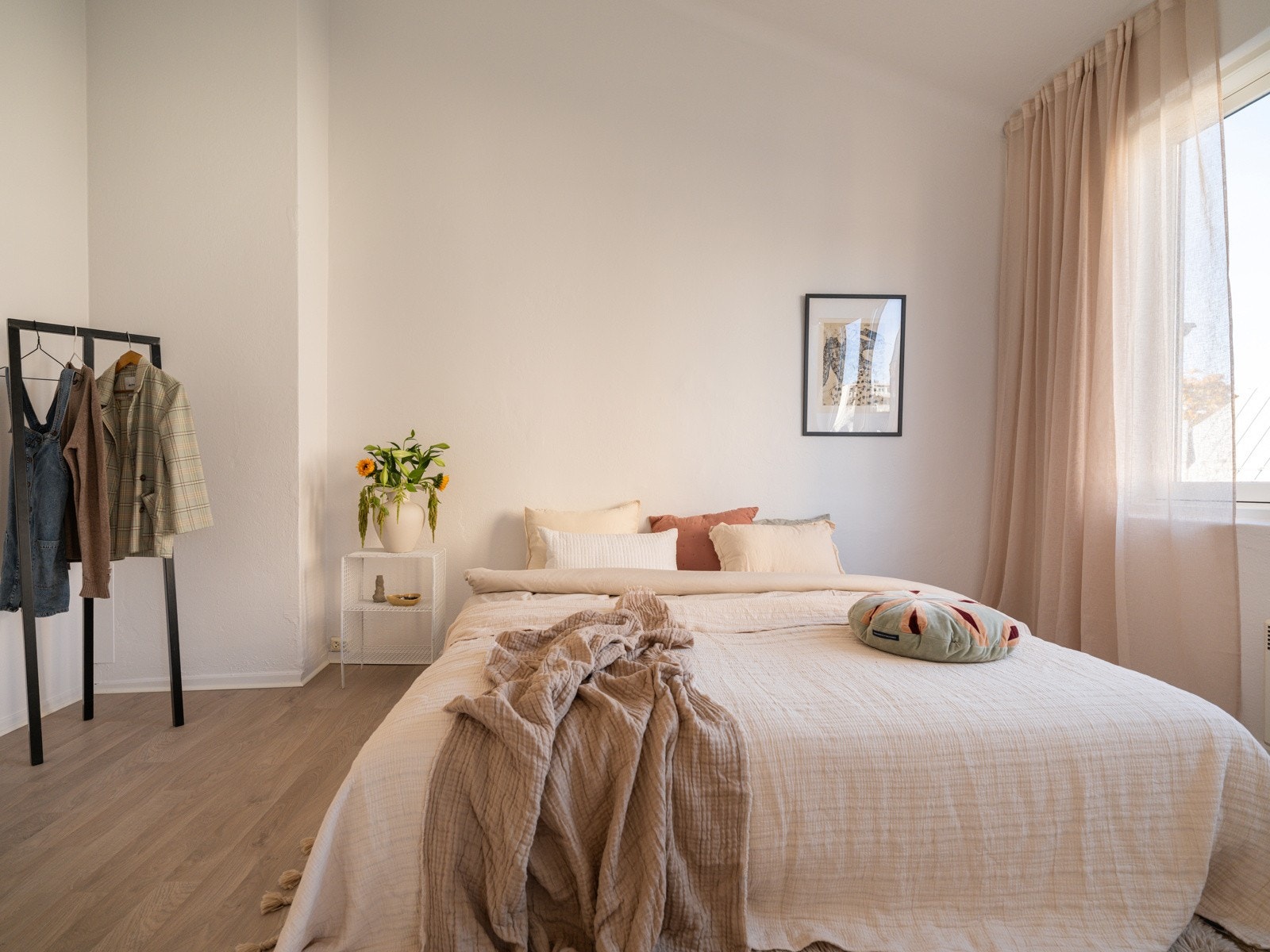 Leiligheten har et stort, lyst og innbydende soverom med laminat på gulv og lysmalte overflater. Galleribilde