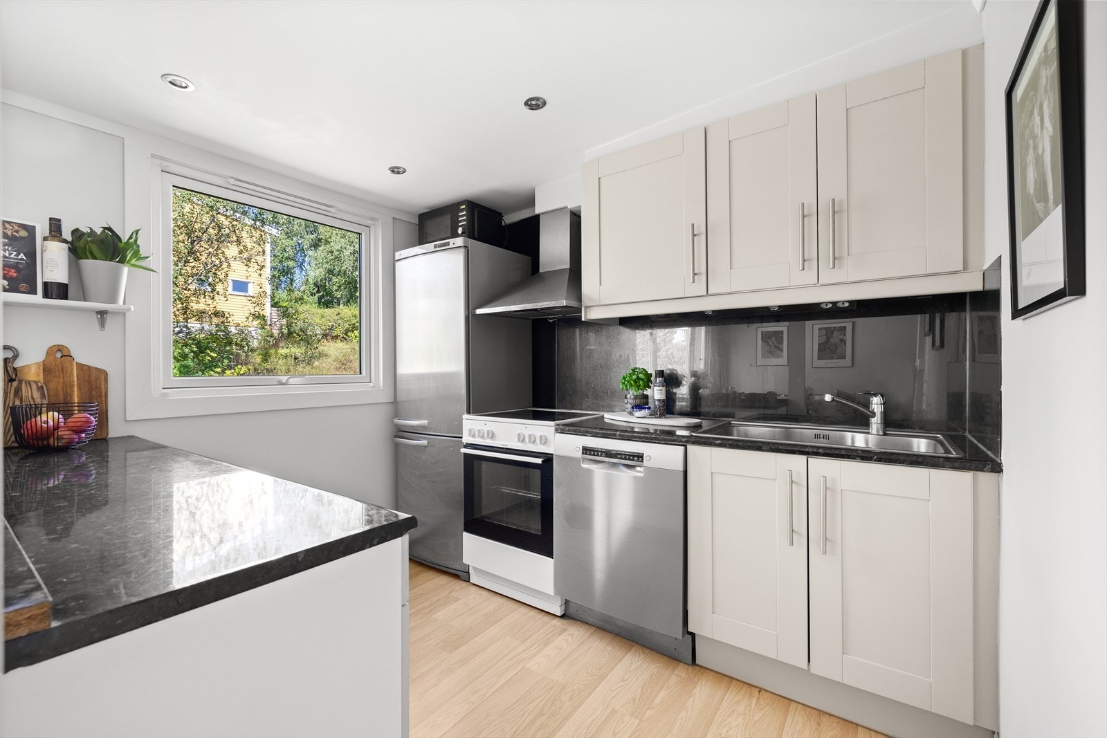 Funksjonelt kjøkken med innredning med profilerte fronter og laminat benkeplate med nedfelt vaskekum. Galleribilde