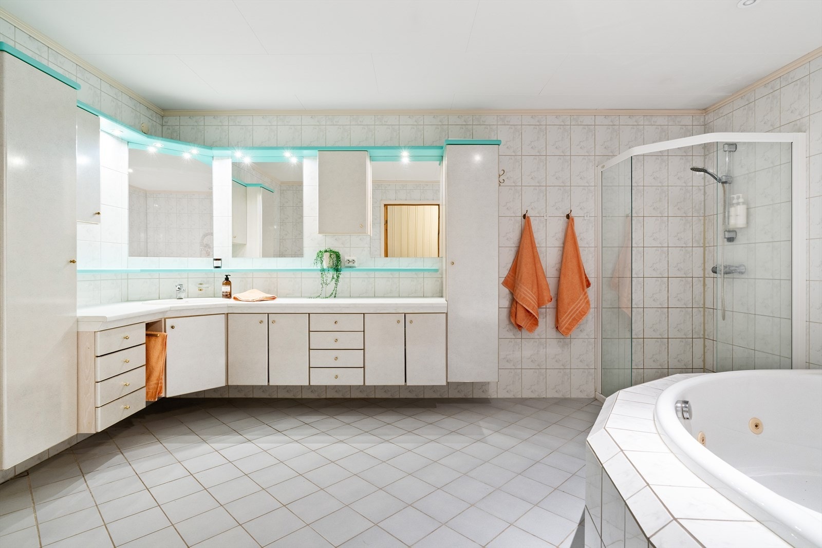 Stort flislagt bad med badekar, dusj, toalett og lys baderomsinnredning Galleribilde