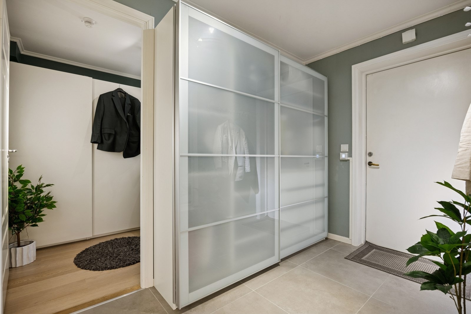 Innbydende entré med god garderobeplass og stilrent flislagt gulv med varme - praktisk og moderne. Galleribilde