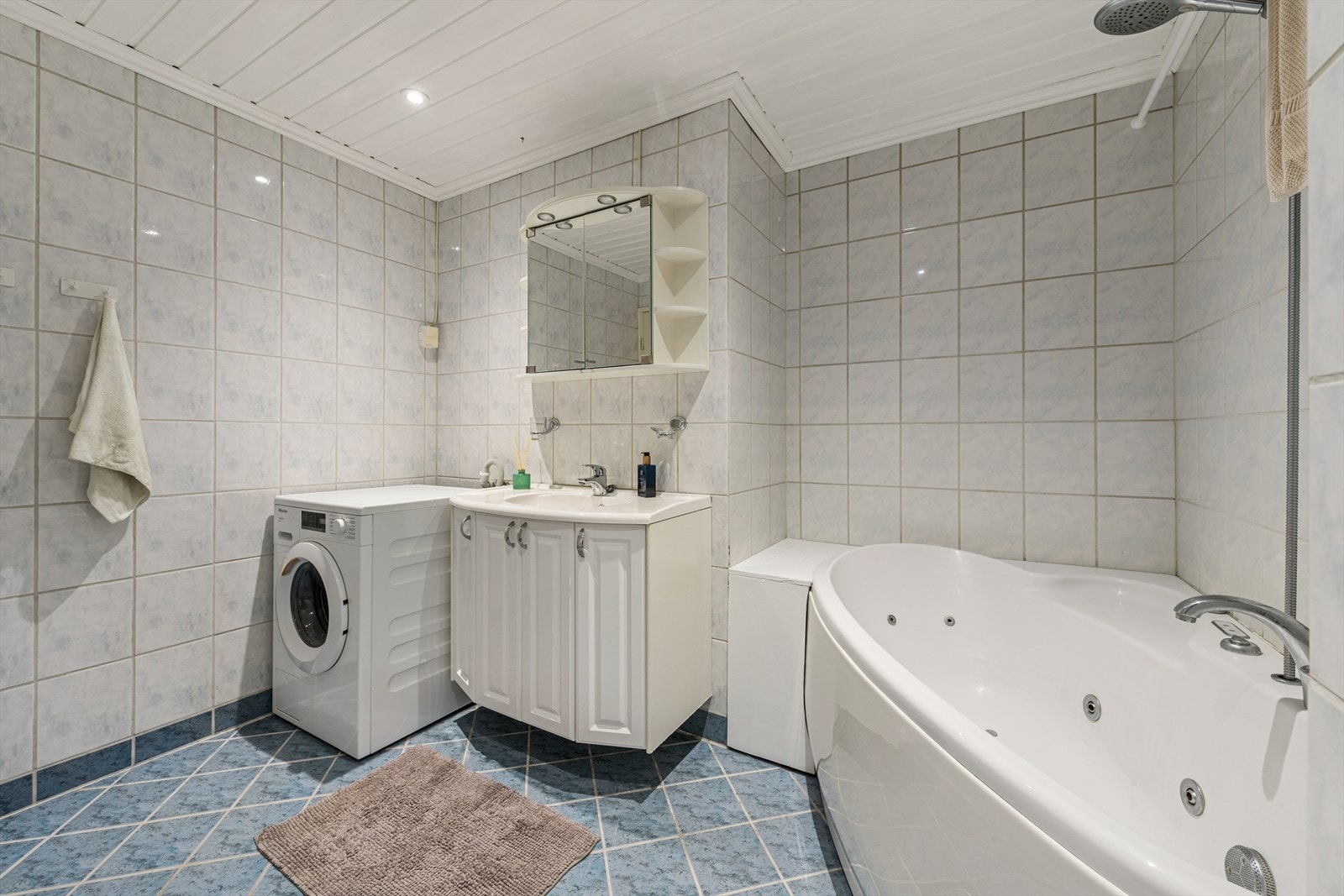 Badet er utstyrt med klosett, hel nedfelt servant, opplegg for vaskemaskin samt baderomsinnredning med servantskap, speilskap og lys over speilet. Galleribilde