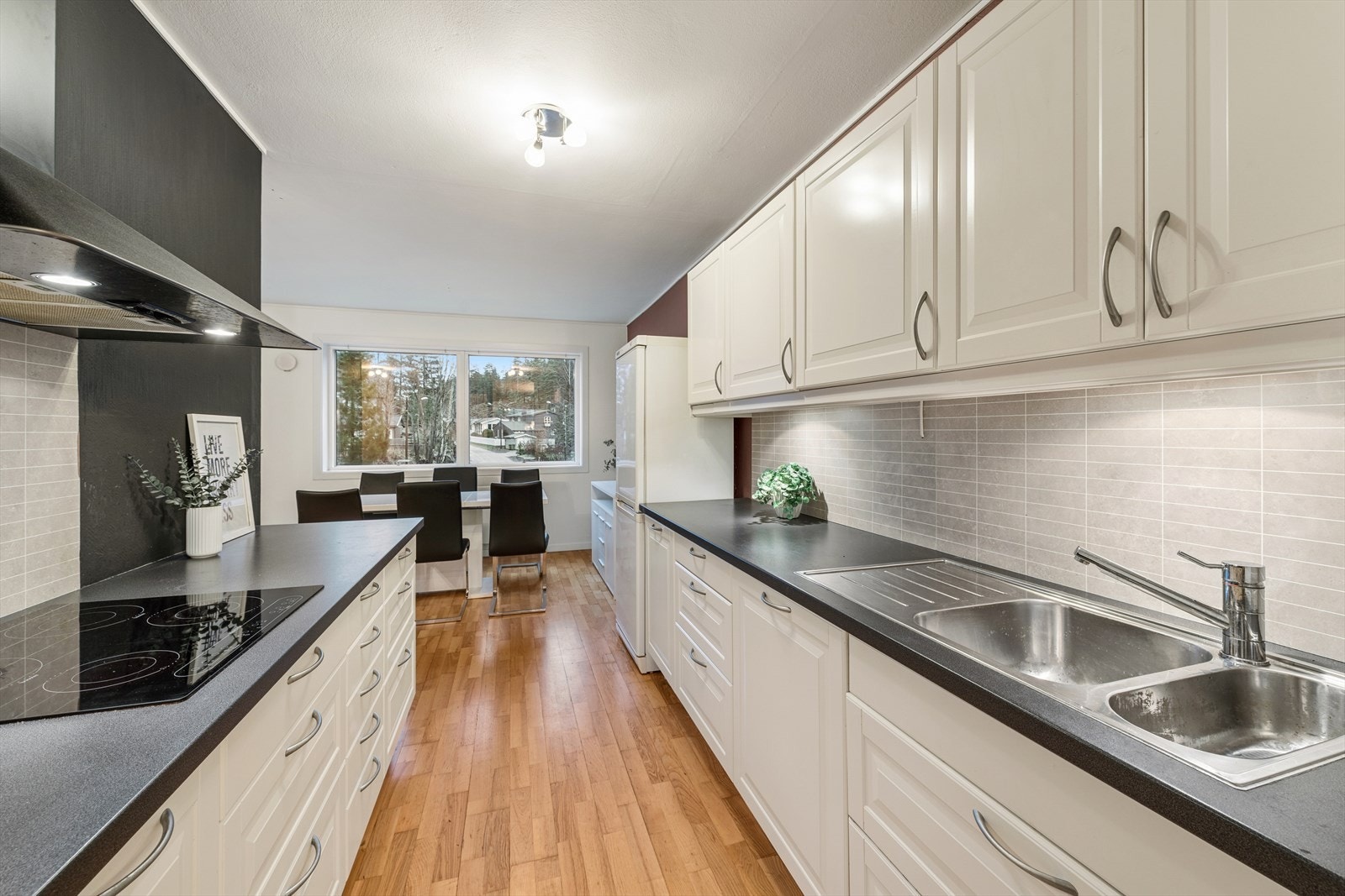 Innredningen består malte profilerte fronter, laminat benkeplate, laminatplater over benken, kullfilterventilator med stål hette og nedfelt benkebeslag i rustfritt stål. Galleribilde