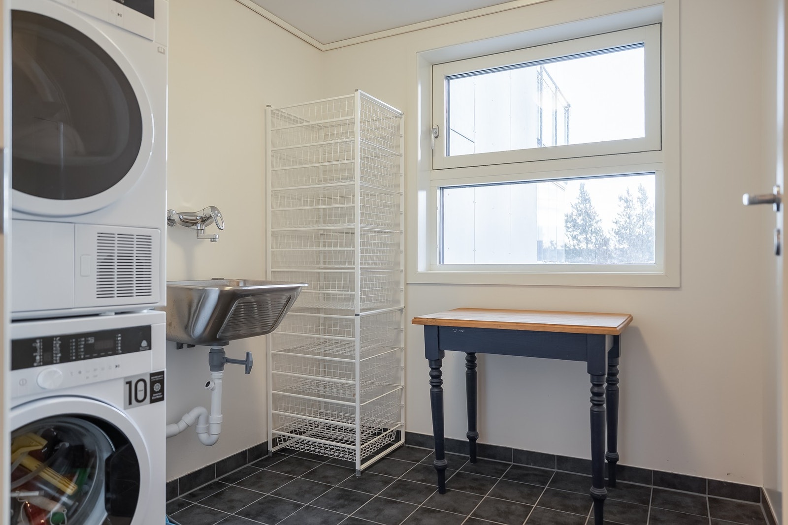 Praktisk vaskerom i tilknytning til badet, innredet med opplegg for vaskemaskin og tørketrommel. Galleribilde