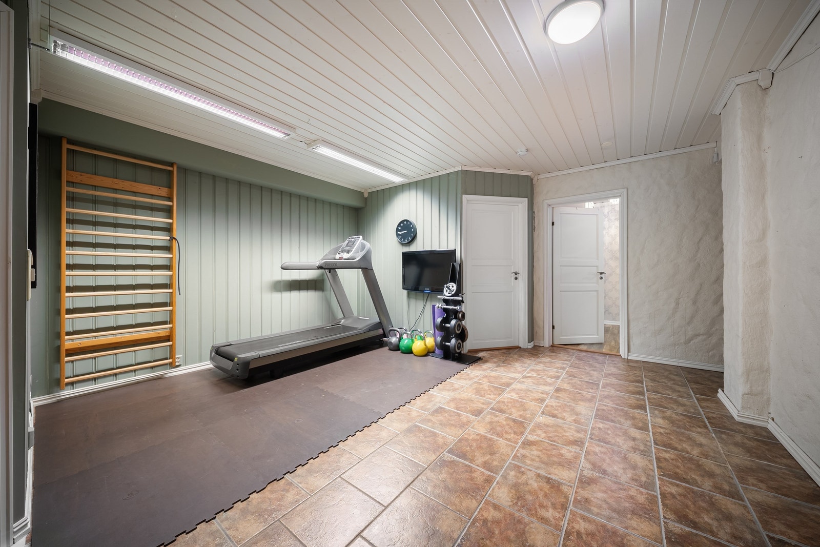 Sokkeletasjens romslige gang er byggemeldt som hobbyrom og fyller i dag rollen som treningsrom. Galleribilde