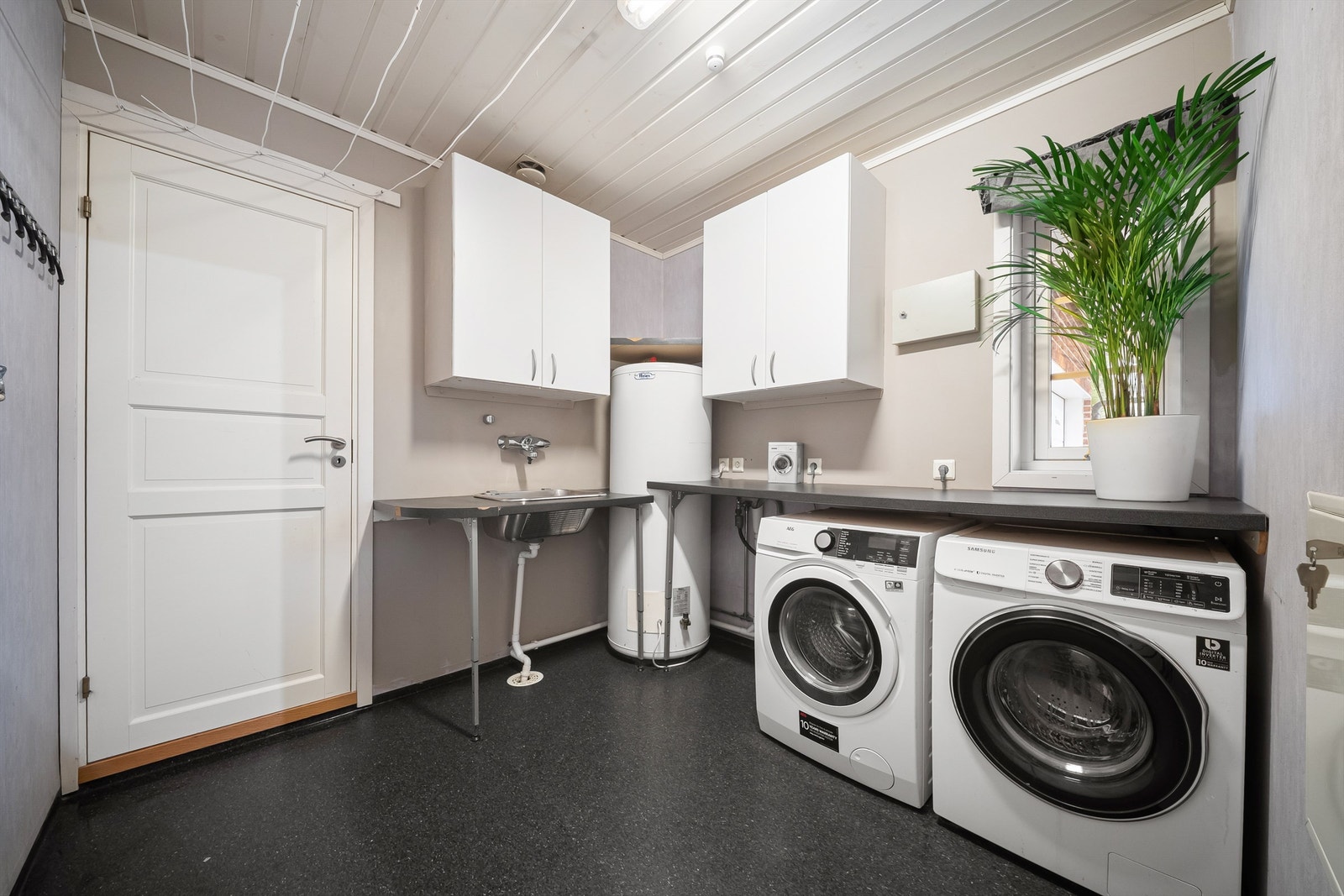 Vaskerommet er i likhet med badet fra byggeåret. God størrelse og praktisk innredning gjør rommet funksjonelt. Berederen er på hele 300 liter og kun for boligens hoveddel. Galleribilde