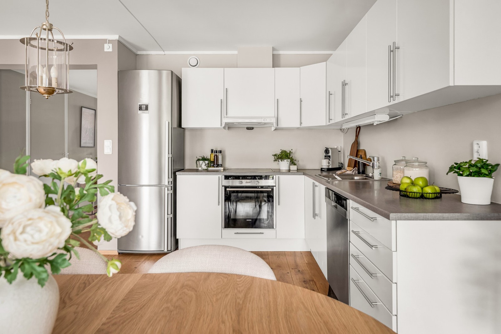 Kjøkkenet er plassert i en praktisk L-form, som gir god arbeidsflyt og bra med skapplass. Galleribilde