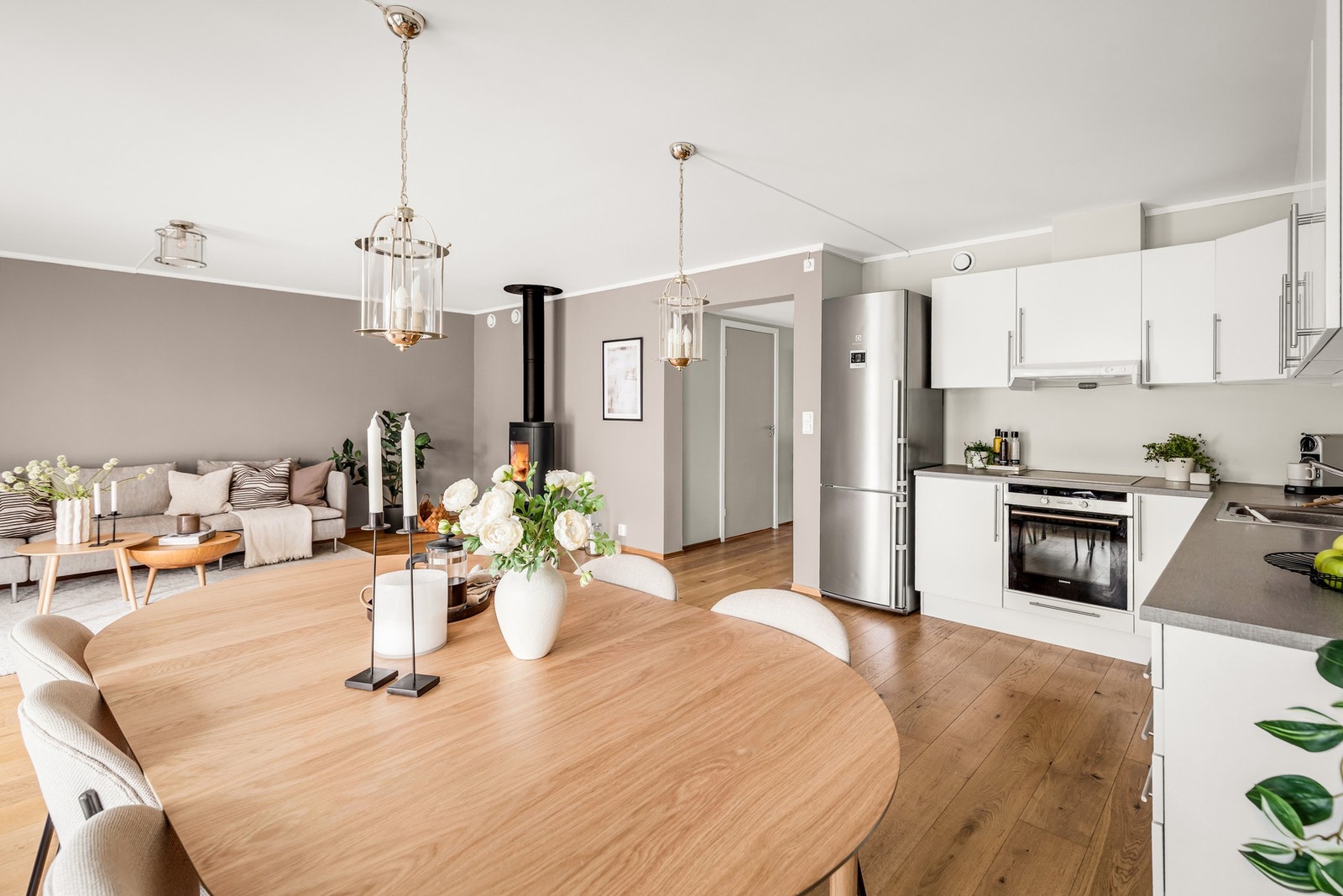 Den åpne løsningen mot kjøkkenet gjør rommet til et sosialt oppholdsrom med en behagelig atmosfære. Her får du et utmerket sted å invitere både venner og familien til hygge og gode måltider. Galleribilde