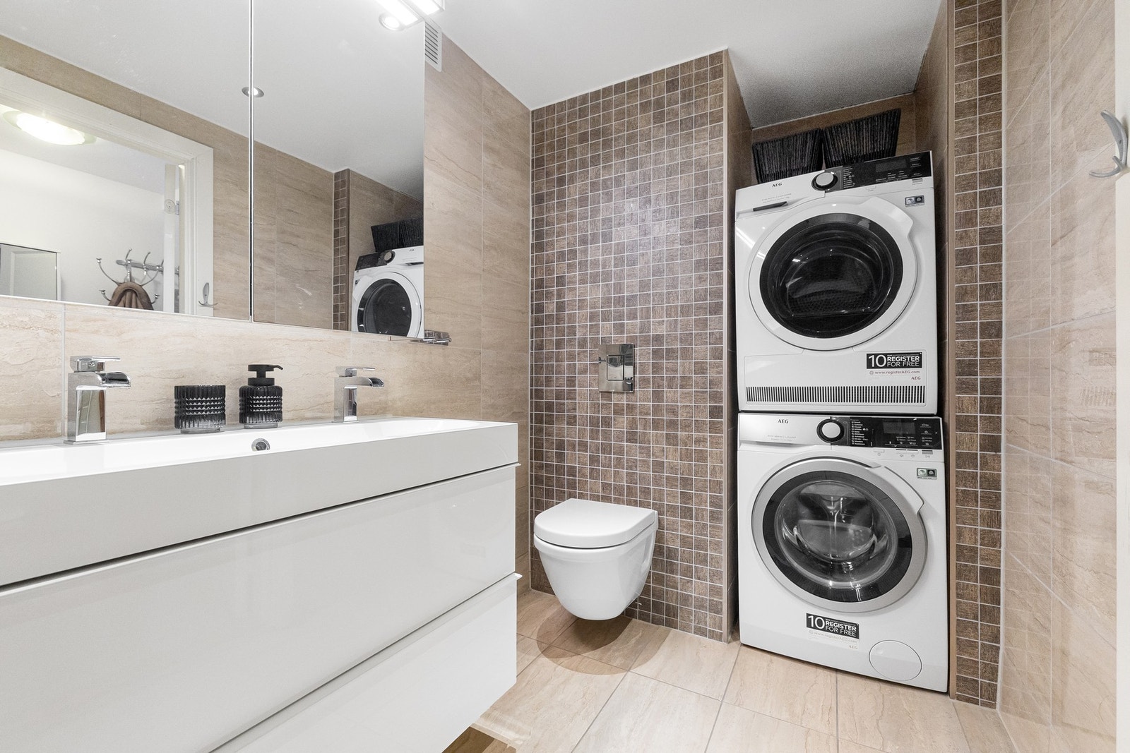 Baderom i 1. etasje er opplyst å være fra 2013. Rommet har flislagt gulv med gulvvarme og flislagte vegger. Himling er nedsenket og utført i glatt malt flate med downlights Galleribilde