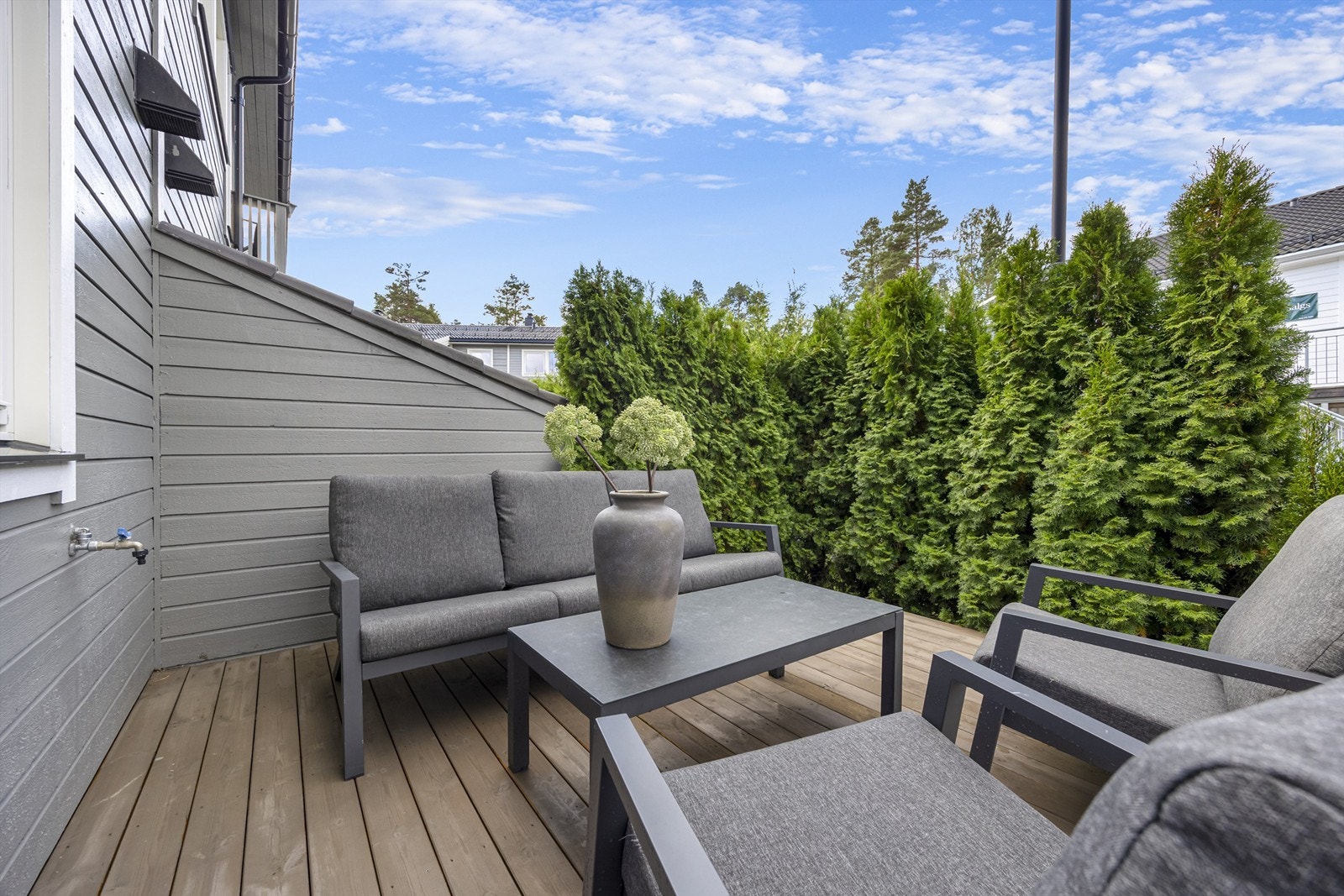 Uteplass med ny terrasse og skjermende beplantning. Galleribilde