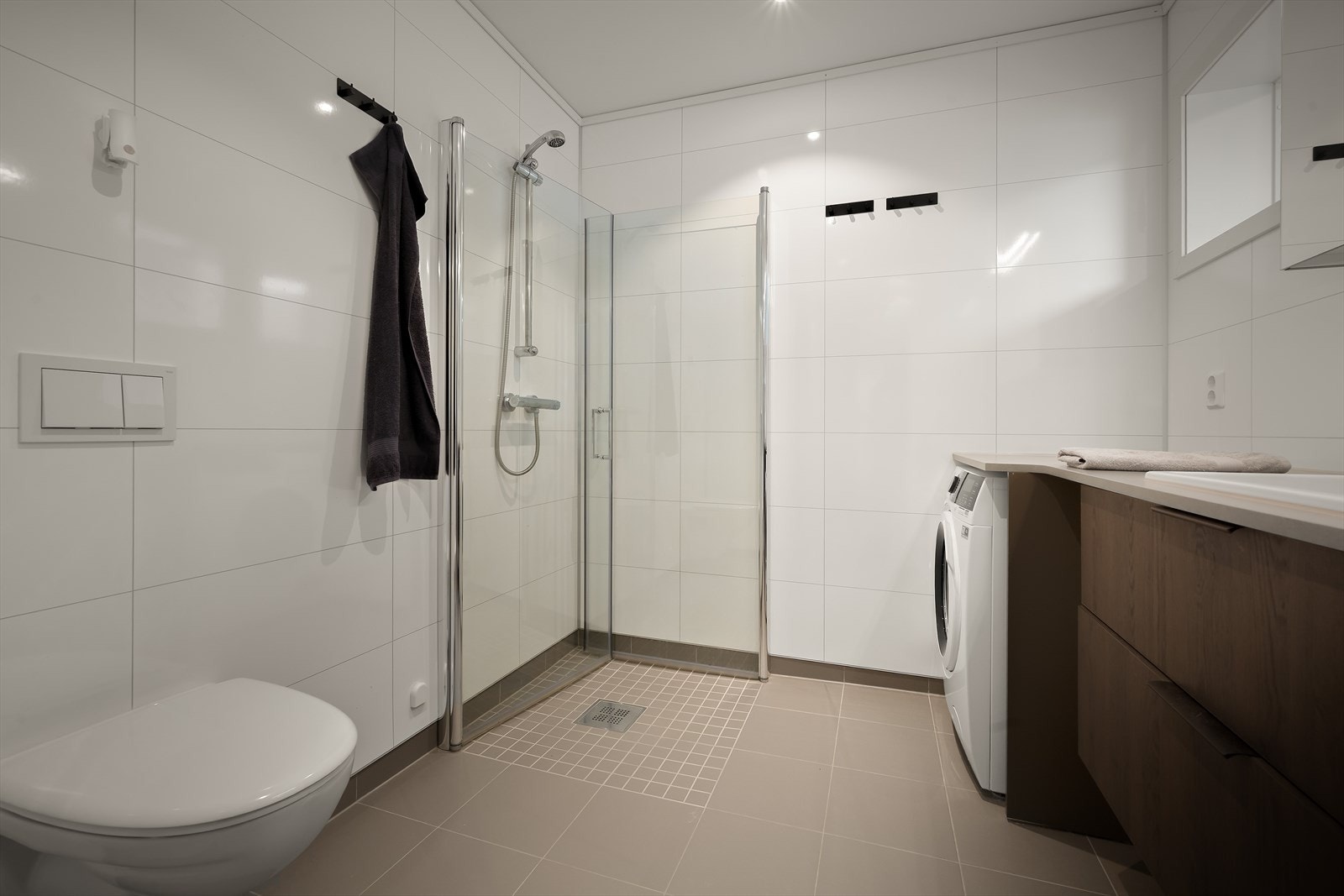 Bad/vaskerom har flislagt golv og LED-spottar i himling Galleribilde