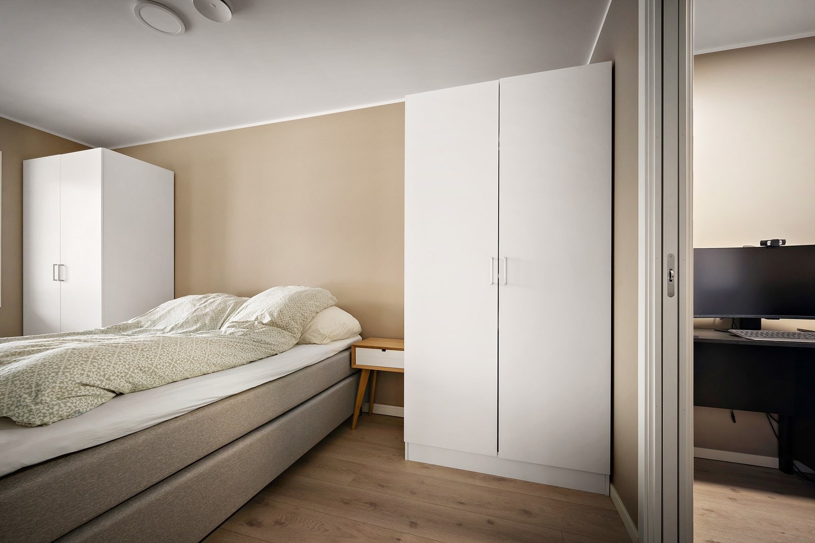 Soverom av god storleik har både garderobeskåp og tilkomst til walk-in-garderobe via skyvedør Galleribilde