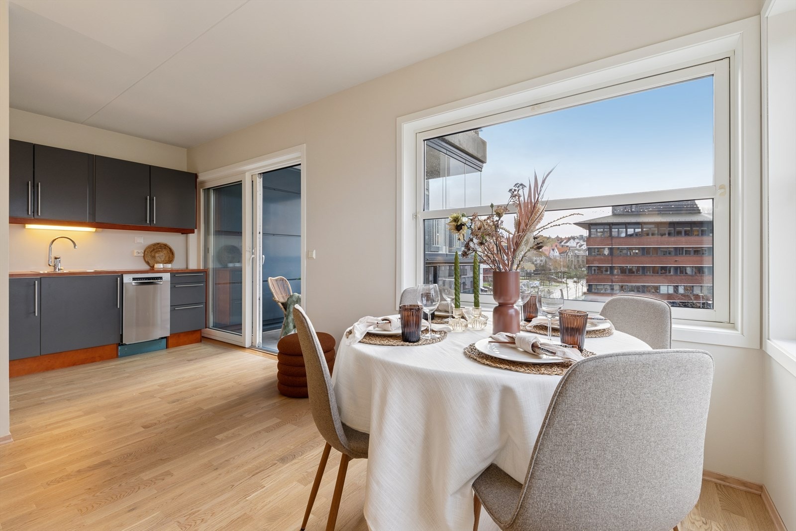 Åpen kjøkkenløsning som knytter oppholdsrommet sammen, med utgang til balkong og rikelig med dagslys Galleribilde