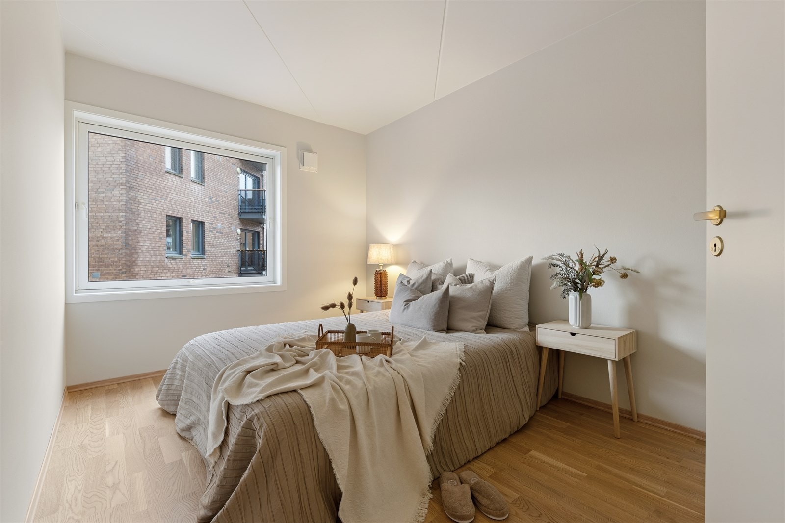 Moderne soverom med stort vindu som slipper inn naturlig lys og et stilrent fargevalg som gir ro og harmoni Galleribilde