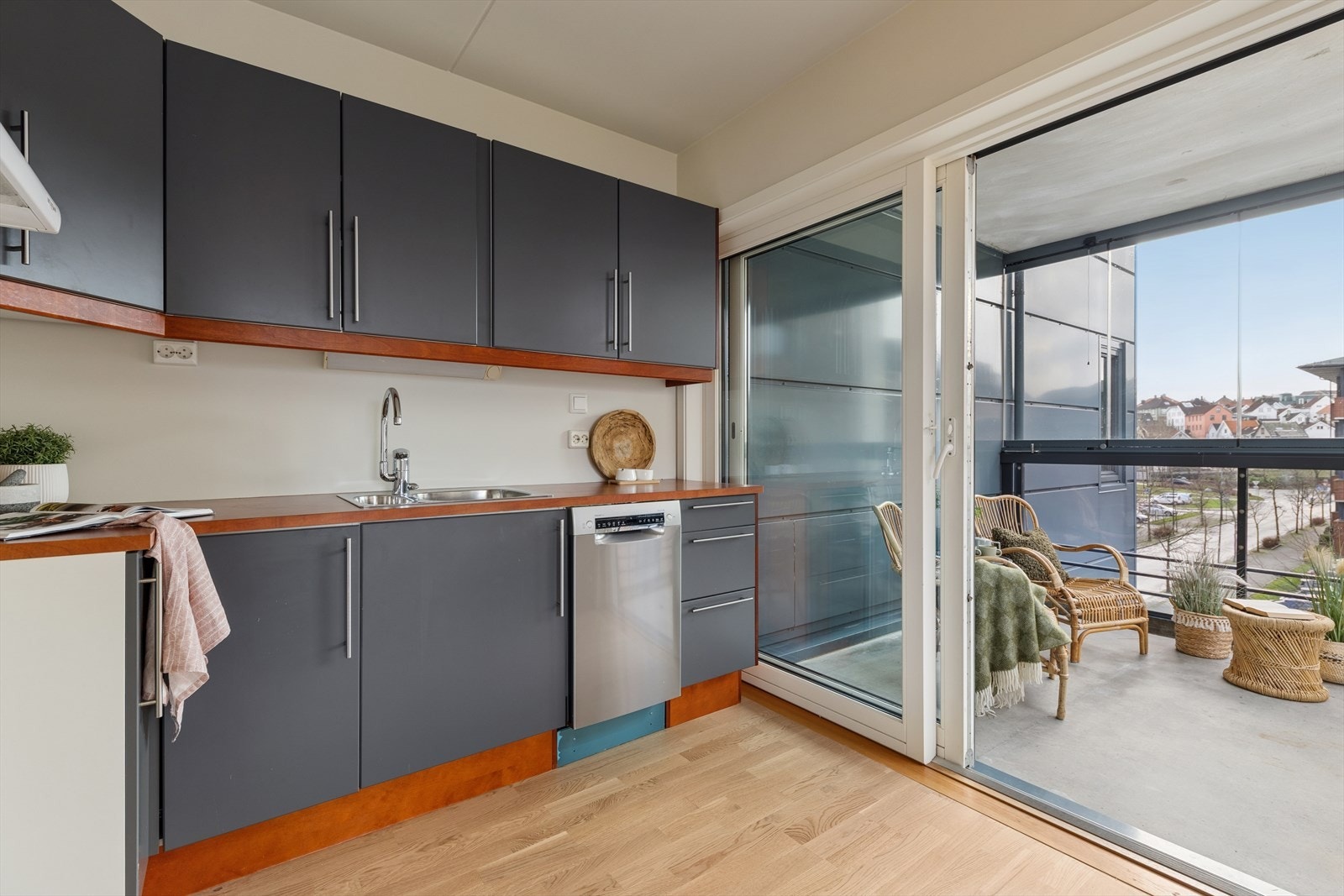 Kjøkken med slette fronter i grå utførelse, rikelig med plass til oppbevaring i overskap og skuffer Galleribilde