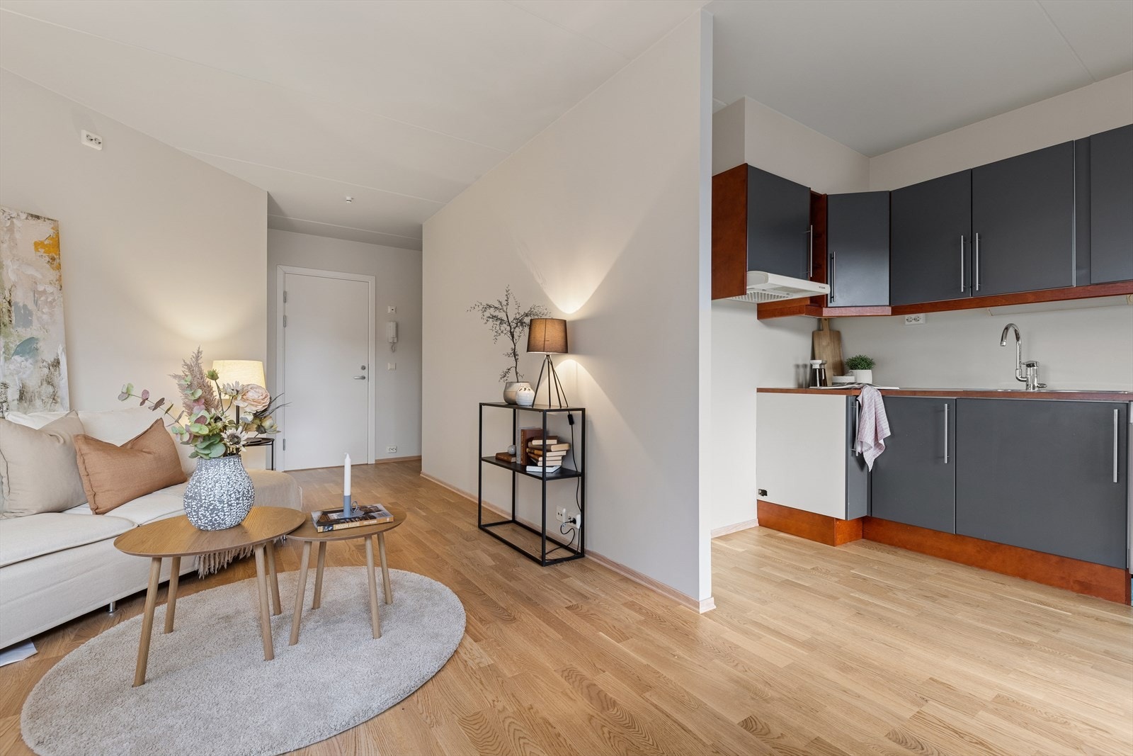 Lys og moderne åpen løsning for stue og kjøkken med gjennomgående gulv og nøye utvalgte farger som gir et elegant og innbydende uttrykk Galleribilde