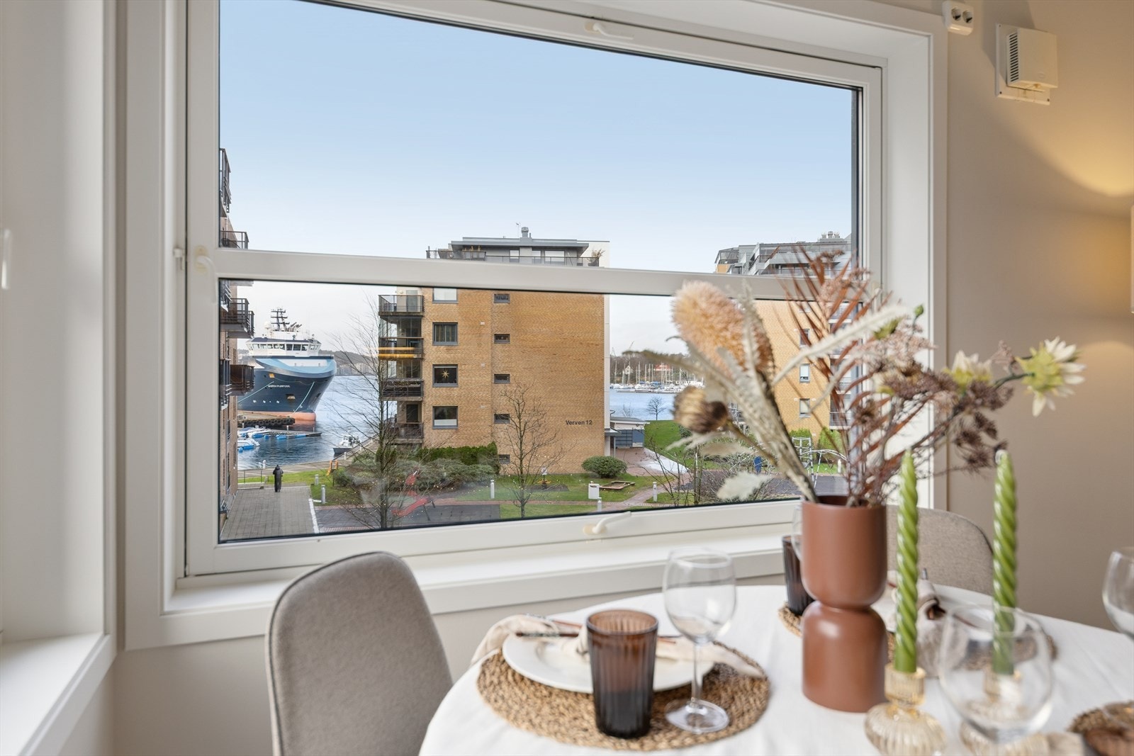 Spiseplass med store vindusflater som rammer inn sjøglimt og skaper en lys og luftig atmosfære Galleribilde